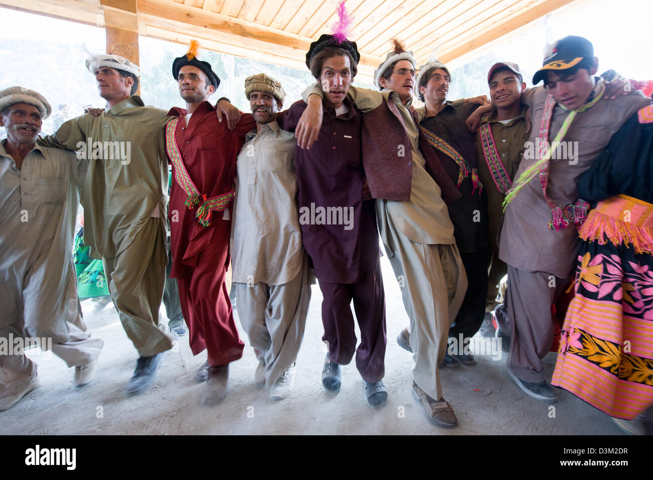 Kalash men dancing in a line at the Kalash Joshi (Spring Festival), Grum Village Charso (dancing ground), Rumbur Valley, Chitral, Khyber-Pakhtunkhwa, Pakistan Stock Photo