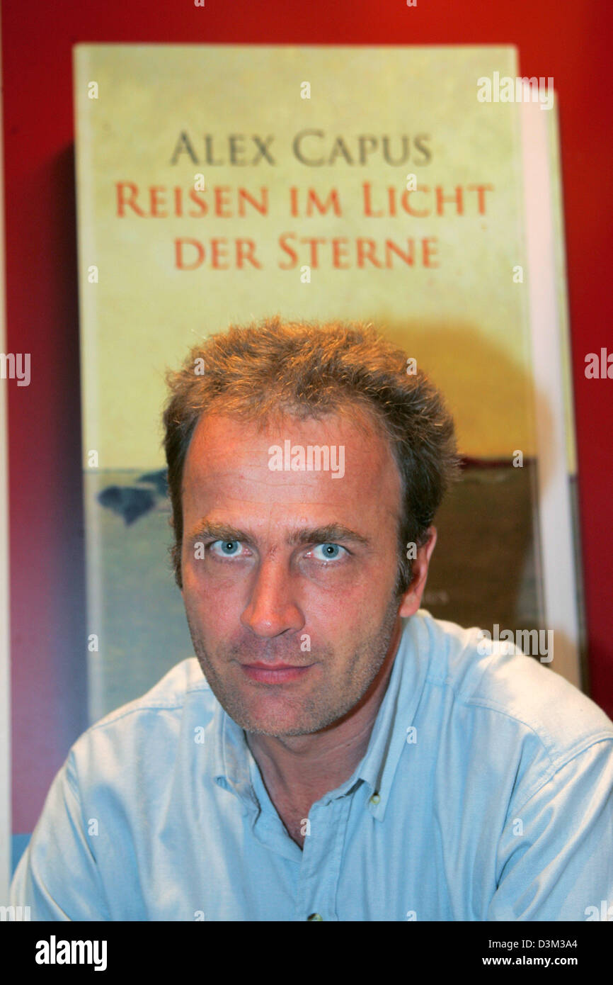 (dpa) - French author  Alex Capus sits in front of an advertising poster for his new book 'Reisen im Licht der Sterne' (travelling in the light of stars) at the international book fair in Frankfurt, Germany, 22 October 2005. Photo: Uwe Zucchi Stock Photo