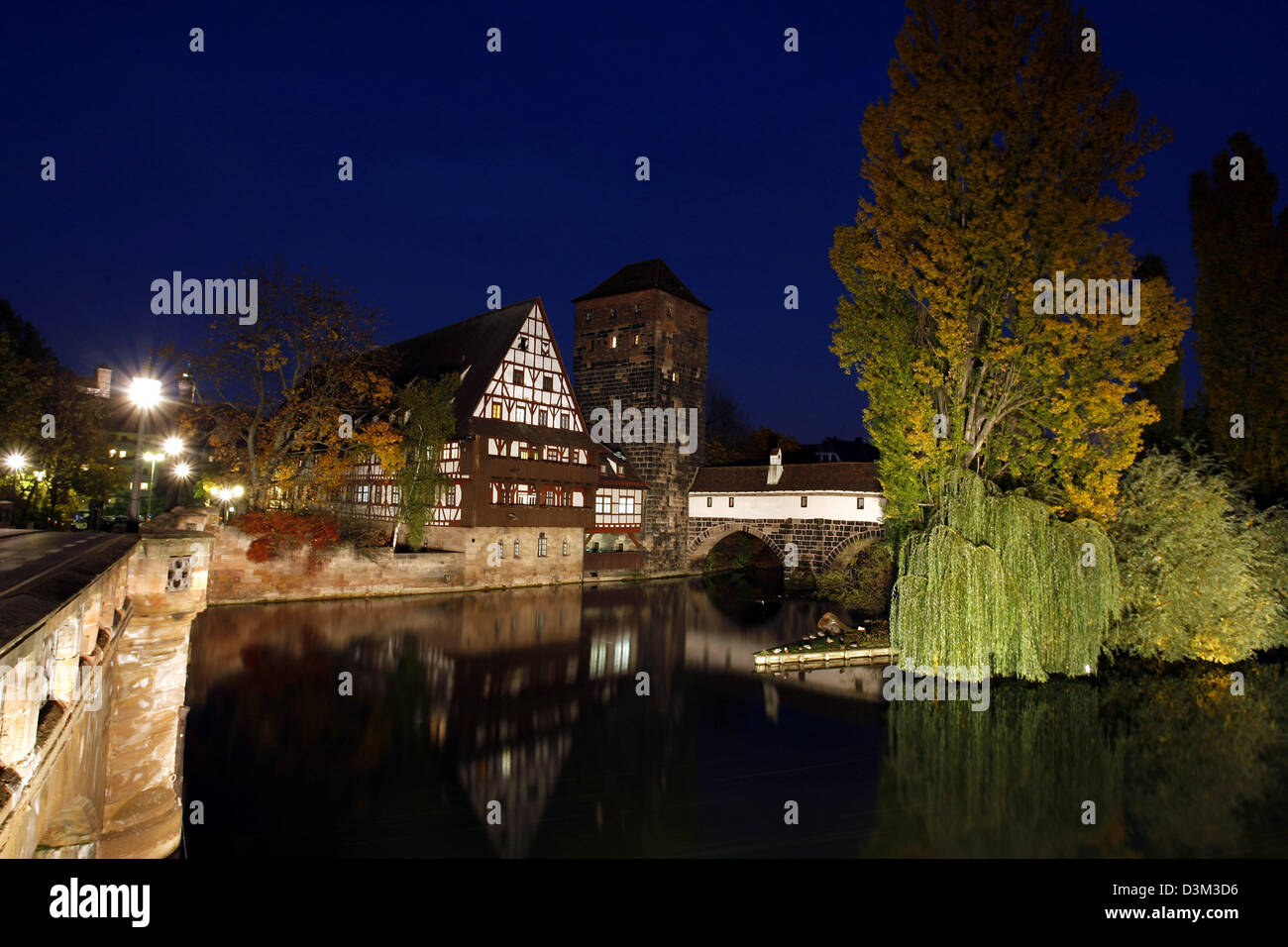 (dpa) - The picture shows the nocturnal view from the Max bridge on the Weinstadel (L), the Henkersteg bridge and the Pegnitz river in Nuremberg, Germany, 26 October 2005. Photo: Daniel Karmann Stock Photo