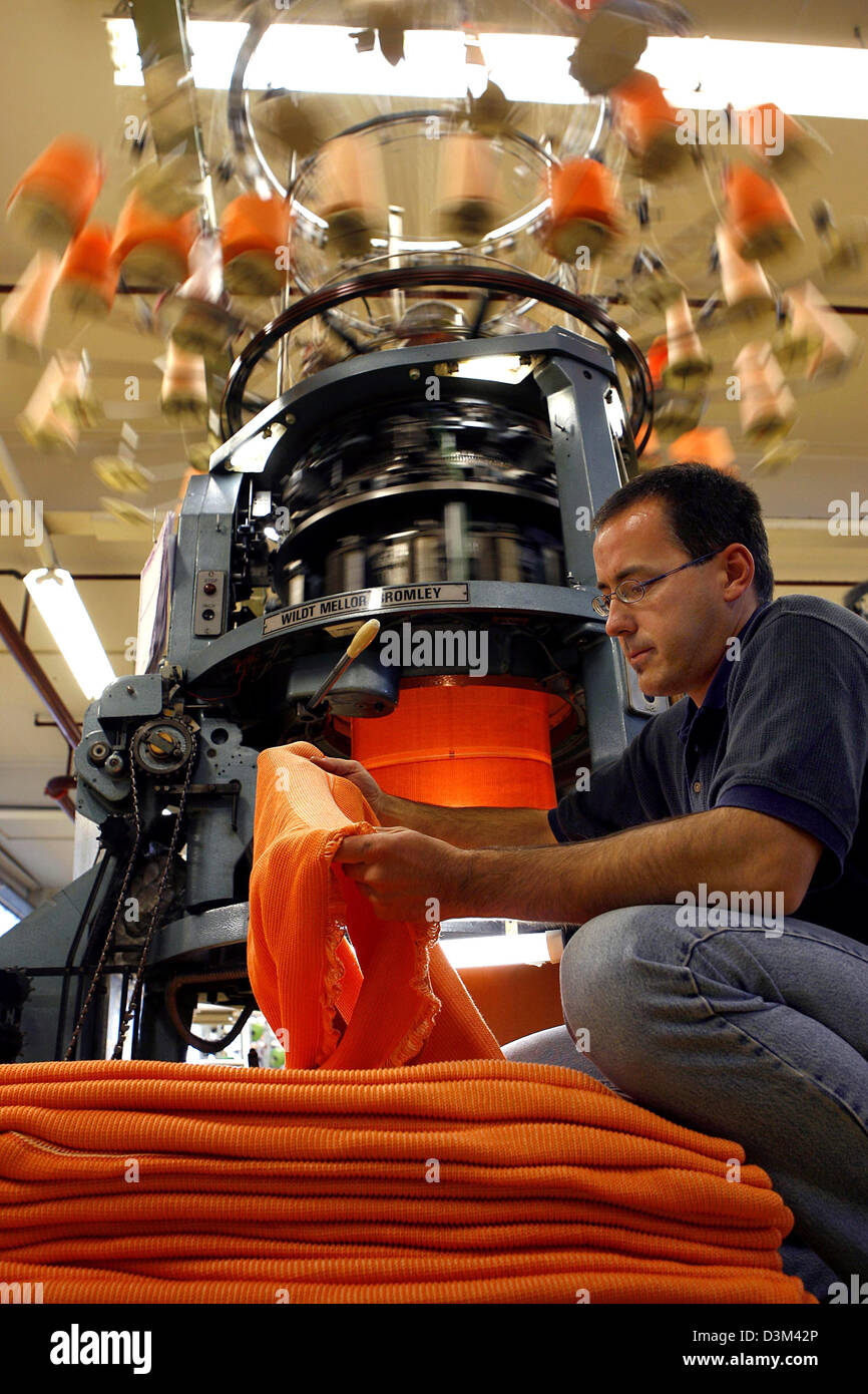 (dpa) An employee examines a piece of fabric, which was produced by a