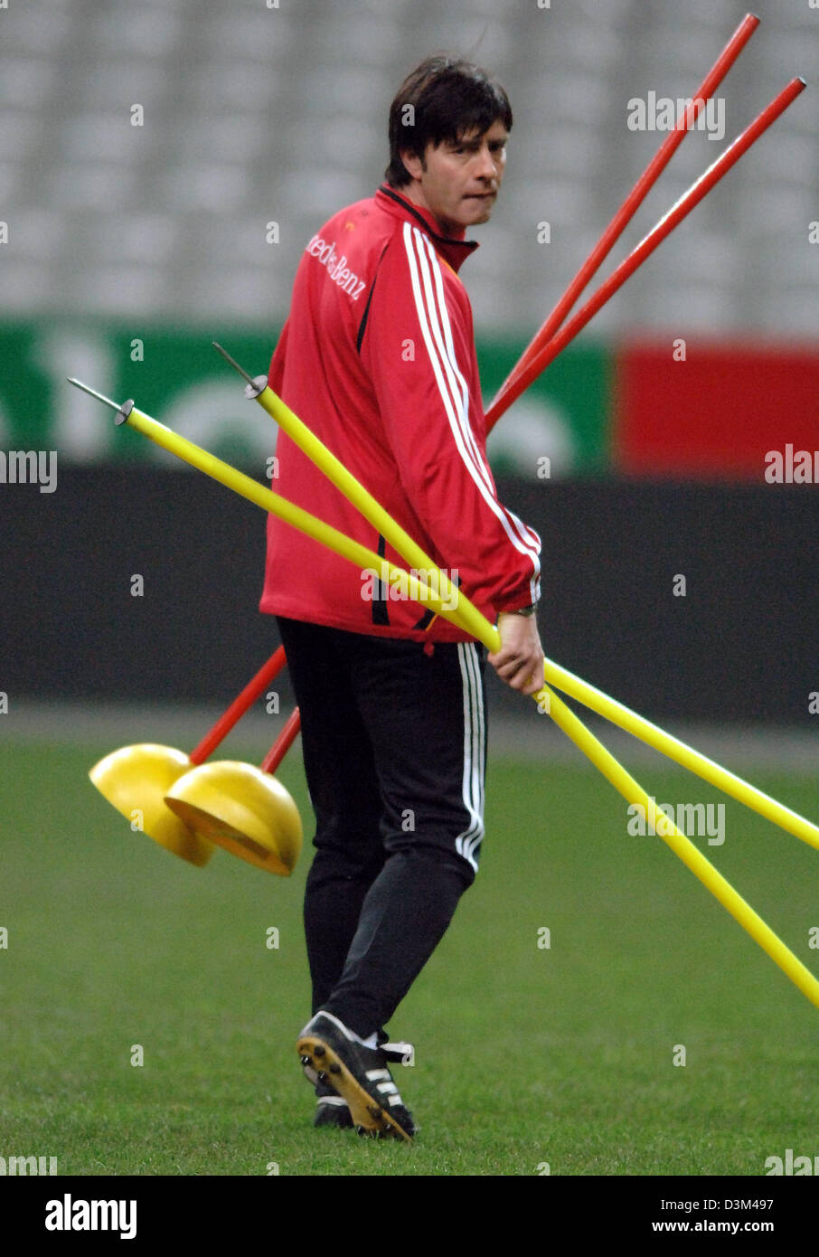 (dpa) - Germany's assistamt coach Joachim Loew distributes red and yellow coloured poles on the pitch during a practice session of the German national soccer squad in Paris, France, Friday, 11 November 2005. Germany prepares for the international friendly against France at the Stade de France in Paris on Saturday, 12 November 2005. Photo Bernd Weissbrod Stock Photo