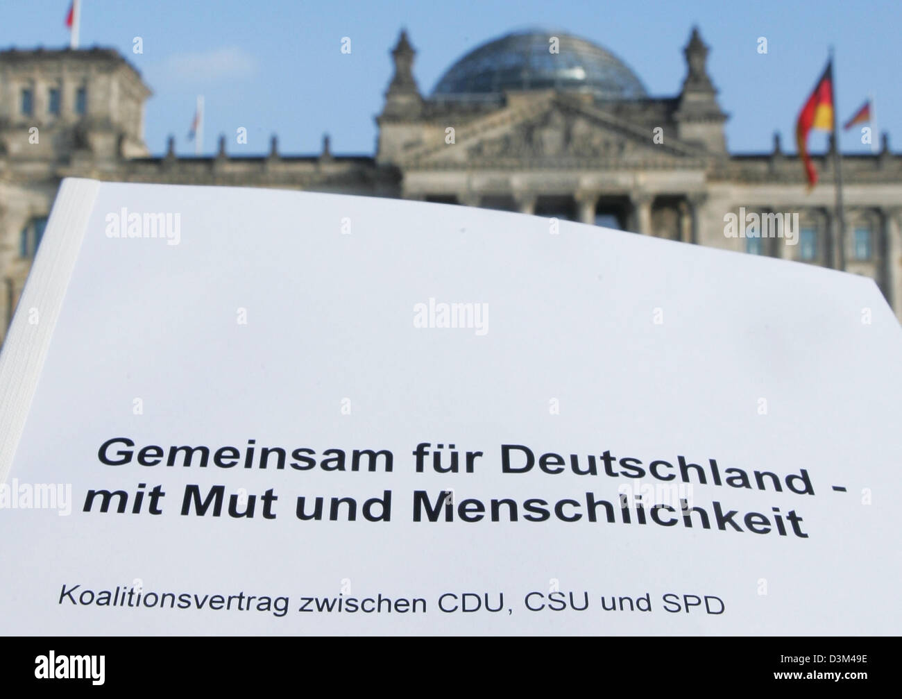 (dpa) - The photo shows the cover of the coalition agreement between the German parties CDU, CSU and SPD in front of the Reichstag in Berlin, Germany, 12 November 2005. The three parties' top leaders presented details of the paper which was negotiated during the last few weeks at a press conference. Photo: Soeren Stache Stock Photo