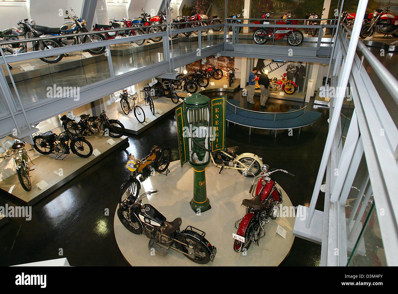 (dpa) - Visitors (C, back) stroll along the galleries featuring bicycles and motorcycles at the 'Zweirad Museum', museum for two-wheelers, in Neckarsulm, Germany, 07 November 2005. According to the management, the museum, which was opened in 1956, accommodates the largest historic collection of two-wheelers in Germany with around 400 exhibits. Photo: Harry Melchert Stock Photo