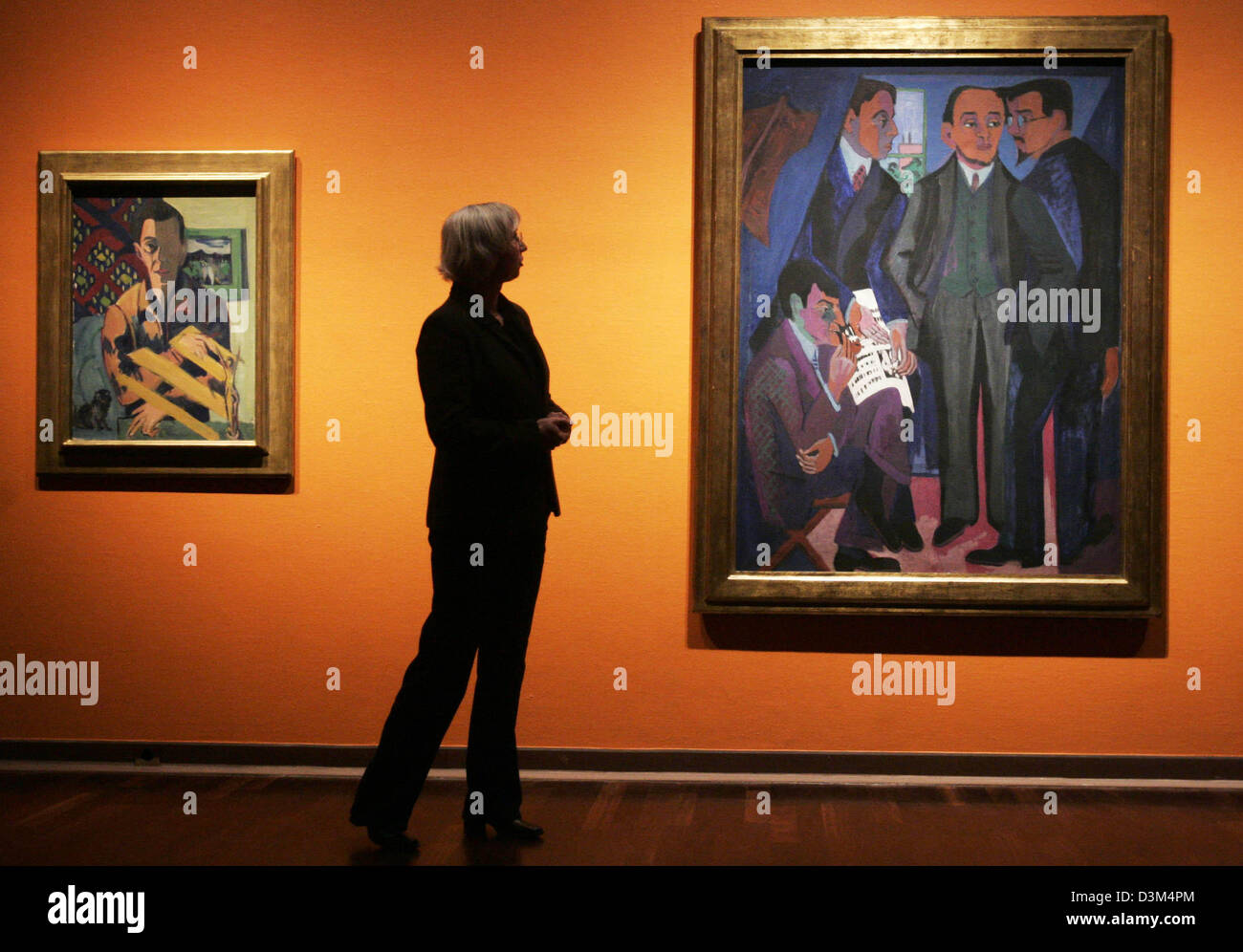 (dpa) - Exhibition curator Jutta Huelsewig-Johnen explains the exhibition's concept while standing between a self-portrait by Ernst Ludwig Kirchner (1935-37, L) and his painting 'An artist group: Mueller, Kirchner, Heckel, Schmidt-Rotluff' (circa 1926) during a press preview at the Kunsthalle (art hall) in Bielefeld, Germany, 17 November 2005. Paintings, drawings and graphics by th Stock Photo