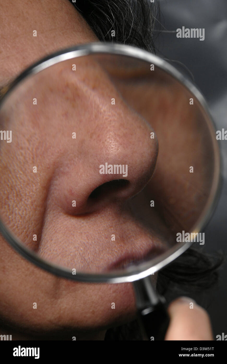 woman nose close up showed with a magnifying glass Stock Photo