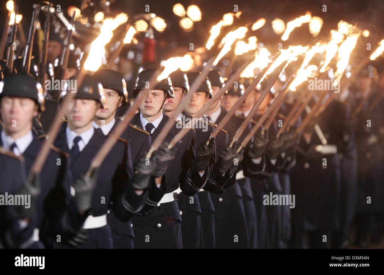 (dpa) - Soldiers photographed during the grand military tattoo for outgoing German Chancellor Gerhard Schroeder in front of the city hall in Hanover, Germany, 19 November 2005. The army torchlight parade for Schroeder on Saturday in the outgoing chancellor's home town marks the start of transition festivities that culminate with Tuesday's inauguration of opposition leader Merkel as Stock Photo