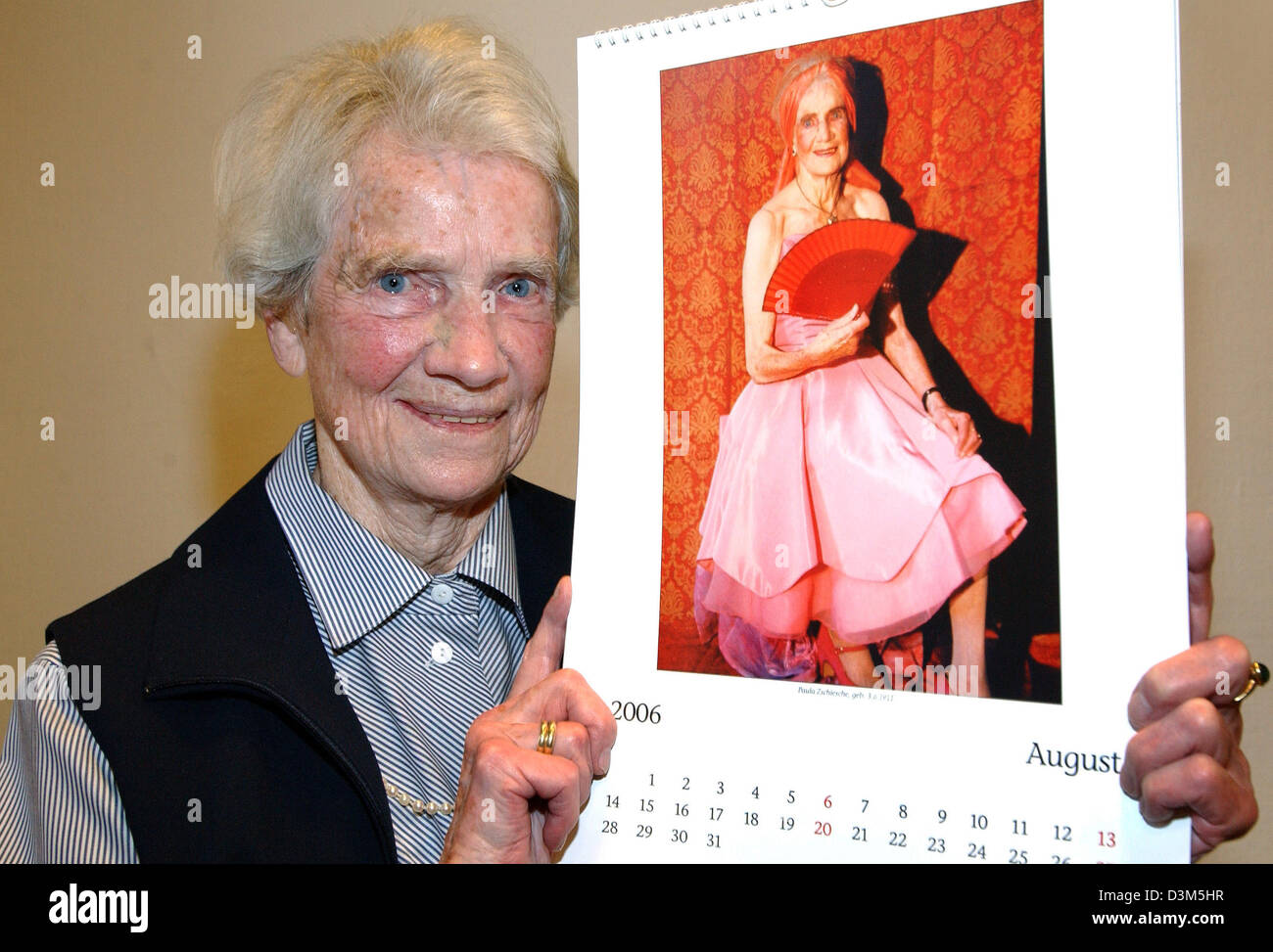(dpa) - 94-year-old Paula Zschische holds a calendar sheet featuring a photo of her wearing a strapless cocktail dress in Luebeck, Germany, 24 November 2005. Eleven women and one man, who are between 77 and 94 years old, from a nursing home in Luebeck were photographed for the calendar. With the proceeds they want to collect money to establish a station for old, dementia patients a Stock Photo