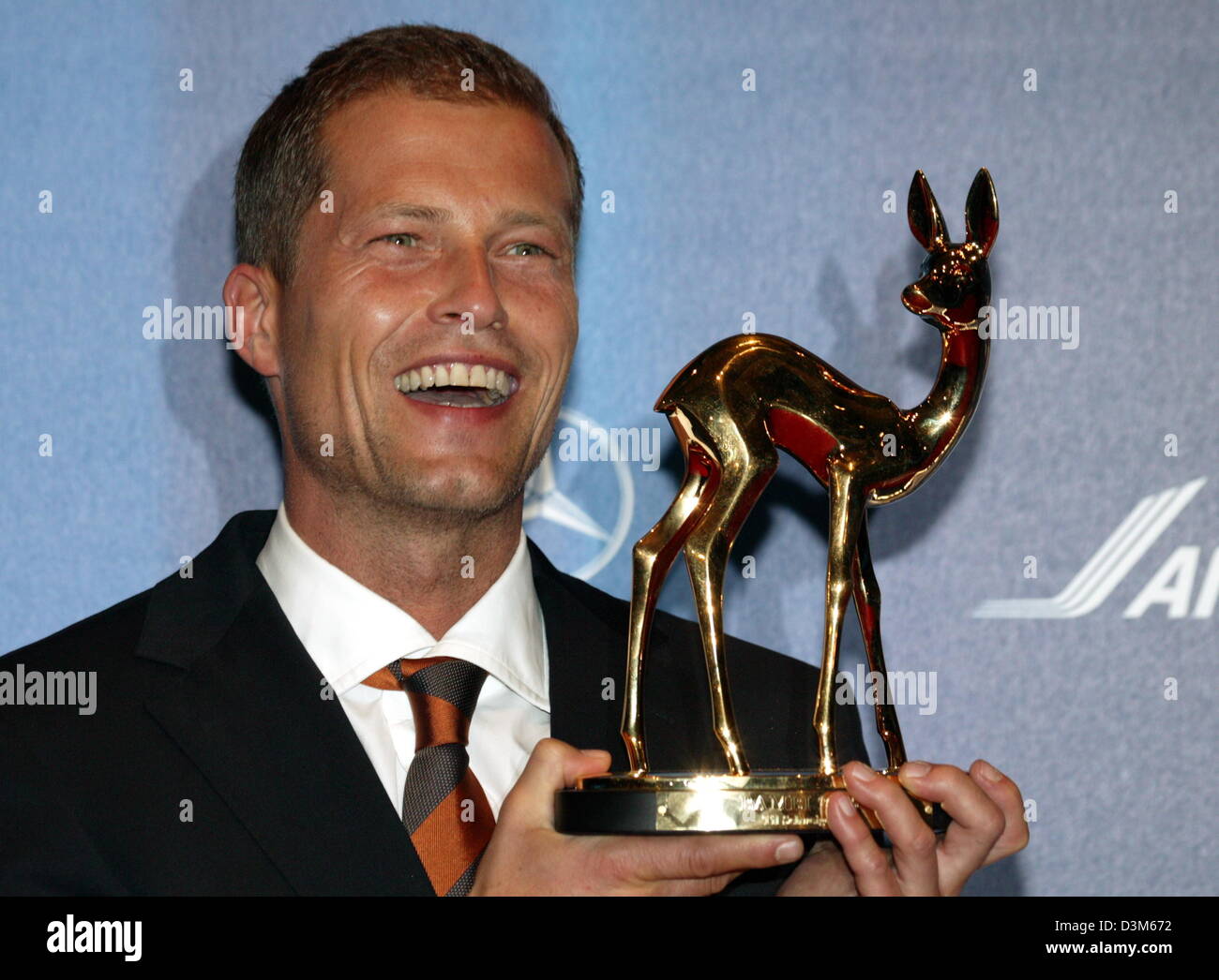 (dpa) - German actor Til Schweiger smiles as he poses with his Bambi Award trophy at the Bambi Awards show at the ICM fair centre in Munich, Germany, Thursday, 01 December 2005. A-list and B-list celebrities arrived to the 57th Bambi Awards show including around 1,000 invited guests fromthe world of business, society, politics and media. It is the first time in ten years that Munic Stock Photo