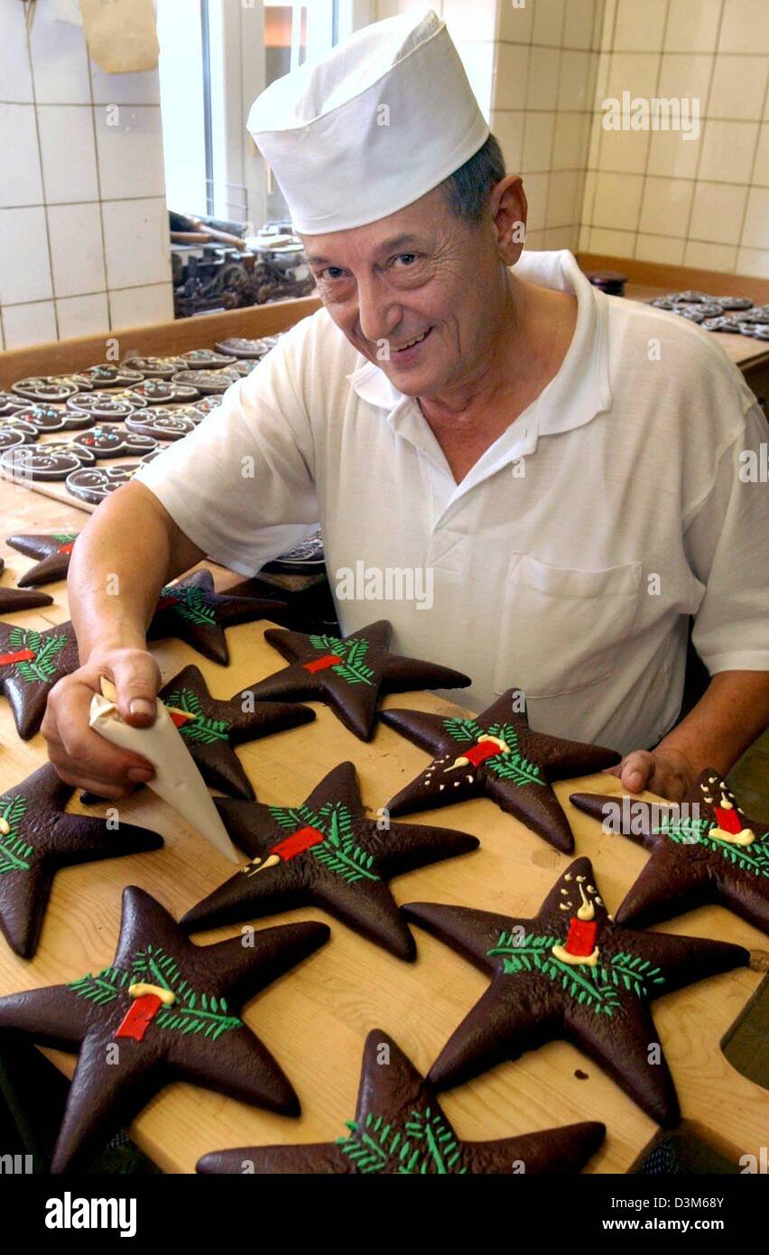 (dpa FILES) - Gingerbread master craftsman Wolfgang Kotzsch garniches gingerbread poinsettias in the gingerbread manufacture Loeschner in Pulsnitz, Germany, 6 September 2002. Kotzsch runs the business founded in 1813 yet in the seventh generation. The pastries particulary popular in Christmas season are confected in a large scale handicraft only in the city of Pulsnitz calling itse Stock Photo