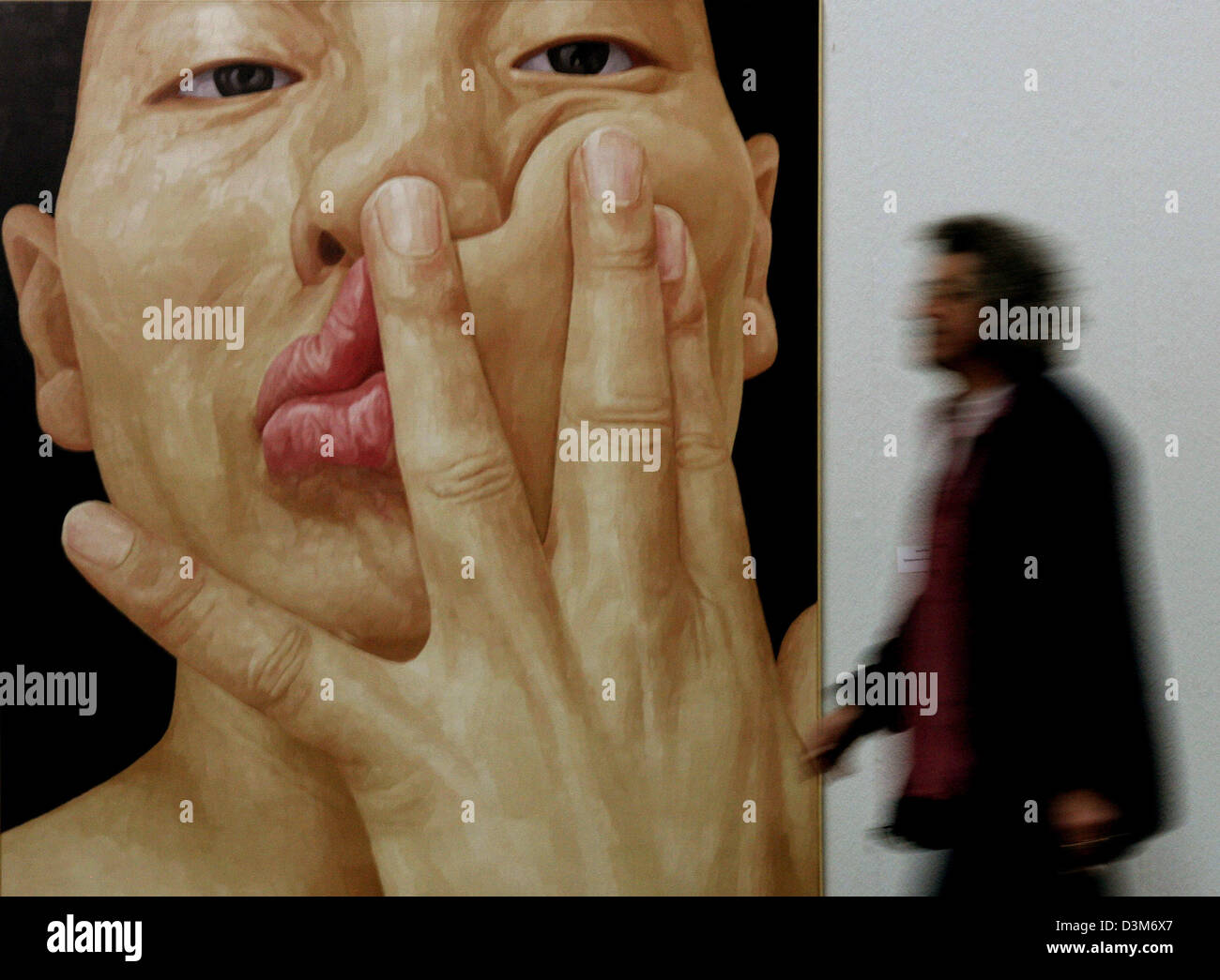(dpa) - A visitor of the 'dreissigpluseiner' (thirtyplusone) special exhibition walks past 'Selbstportrait als ein Mensch' (self-portrait as a person) by Ung-Pil Byen at the large art exhibition in Duesseldorf, Germany, 08 December 2005. About 350 artists show their works of art here between 11 December 2005 and 08 January 2006. Photo: Roland Weihrauch Stock Photo