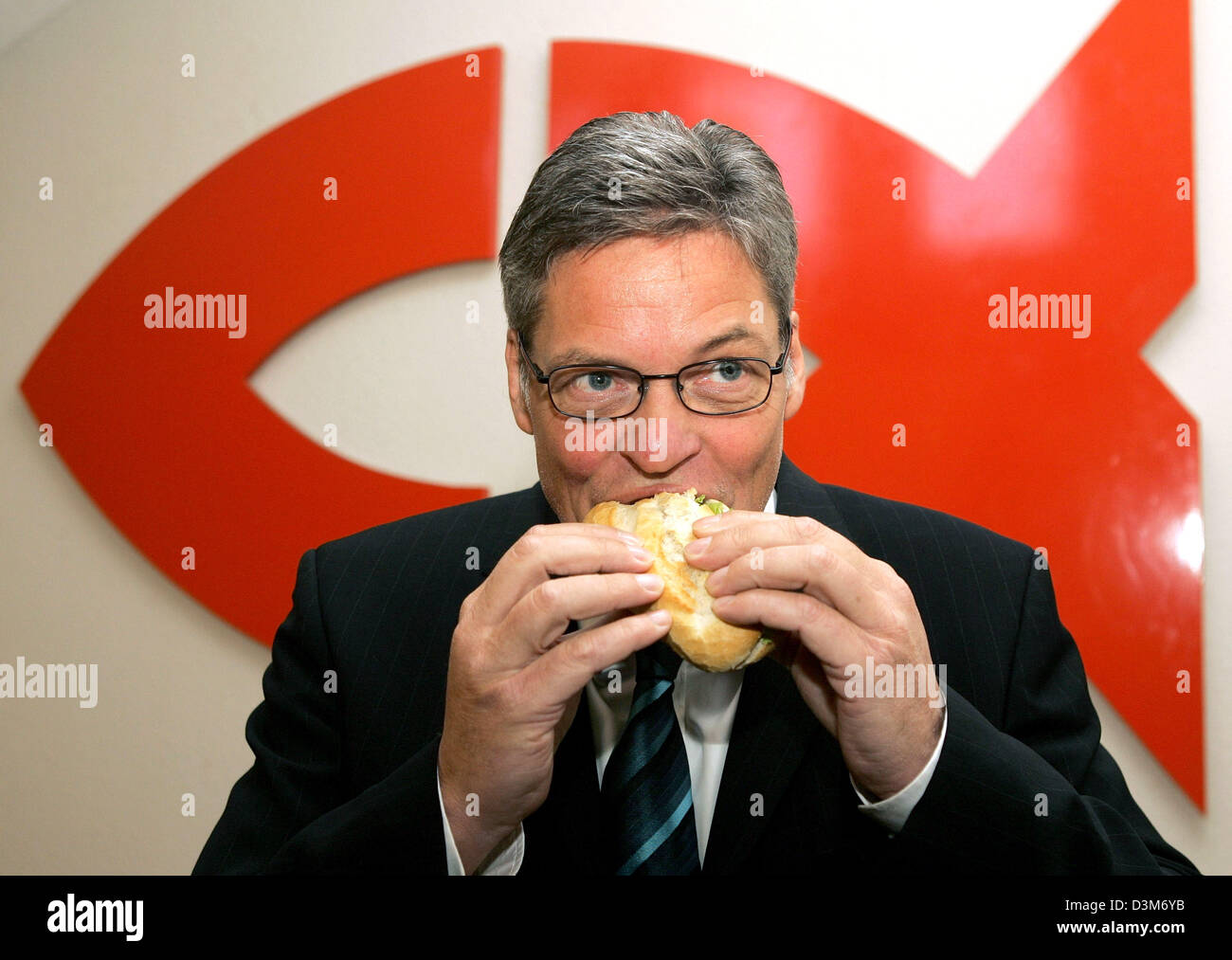 (dpa) - Heiner Kamps bites with joy into a fish bread roll while introducing himself as Nordsee's new shareholder and new CEO in front of a Nordsee logo at the company's headquarters in Bremerhaven, Germany, Thursday 08 December 2005. Prior to his introduction the company announced its future plans and development agenda. Photo: Ingo Wagner Stock Photo