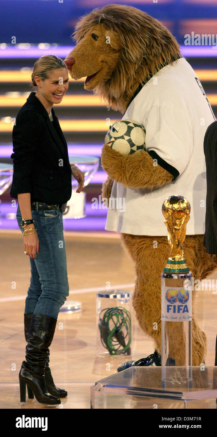 (dpa) - Model Heidi Klum laughs while standing next to World Cup mascot Goleo IV prior to the final rehearsal for the FIFA World Cup 2006 main draw at the fair hall in Leipzig, Germany, 08 December 2005. Preparations for the FIFA World Cup 2006 main draw, which will take place in Leipzig on 09 December 2005, are running at full speed. About 4,000 guests, among them 1,500 journalist Stock Photo