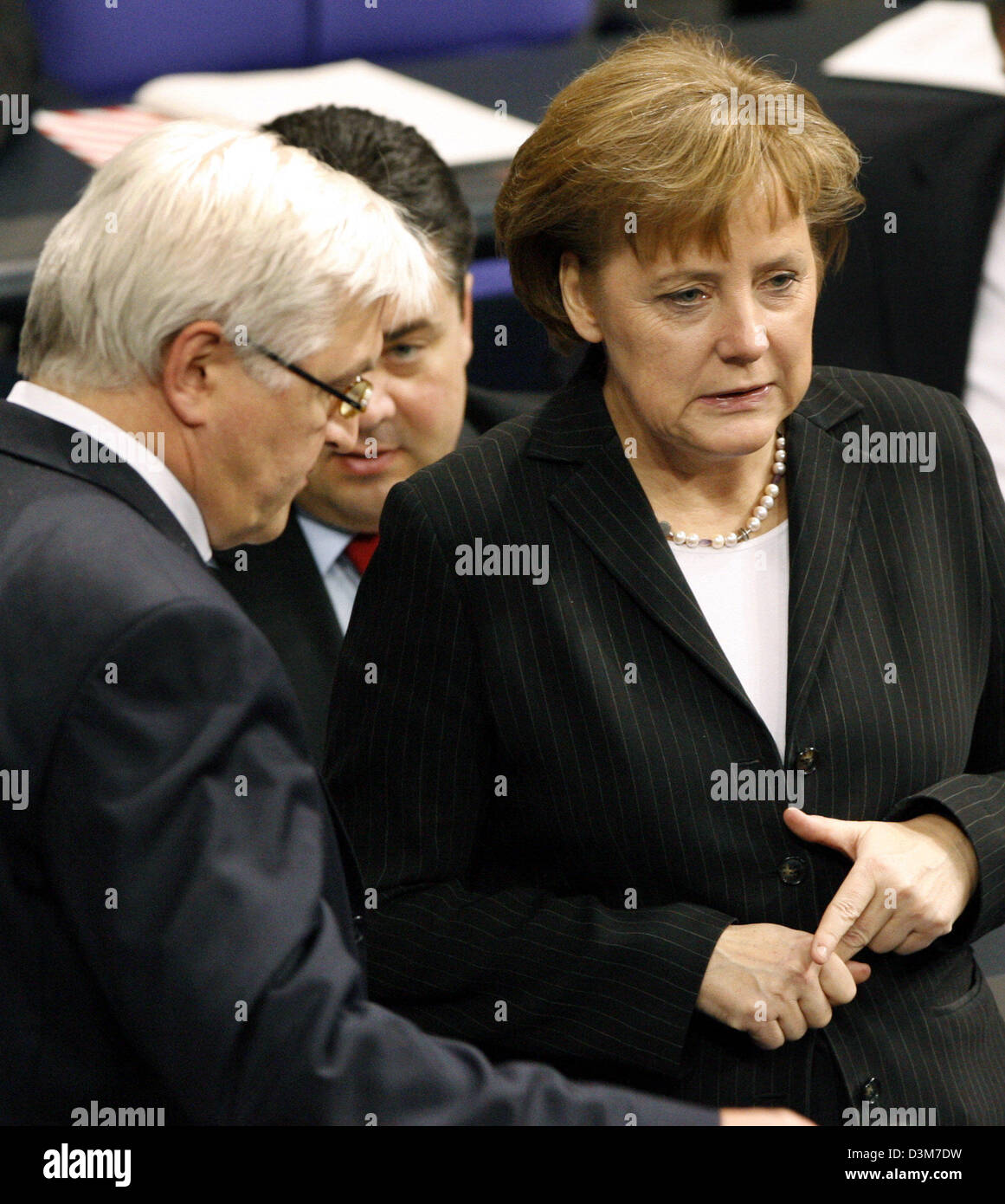 (dpa) - German Chancellor Angela Merkel (CDU) (R) and Foreign Minister Frank-Walter Steinmeier (SPD) (L) talk to each other during a parliamentary debate at the German lower house of parliament Bundestag in Berlin, on Wednesday, 14 December 2005. In the background German Environment Minister Sigmar Gabriel (SPD). Germany played no part in the US abduction of a German citizen who wa Stock Photo
