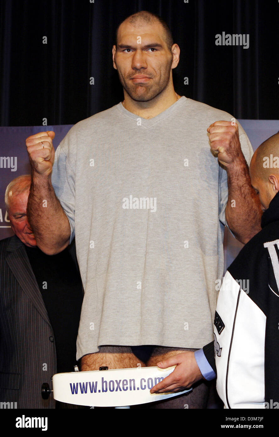 (dpa) -  Russian boxer Nikolai Valuev raise their fists as he stands on the scale during the public weighing in Berlin, Friday, 16 December 2005. Valuev is going to challenge US heavyweight boxing world champion John Ruiz in the WBA title bout in Berlin, Saturday, 17 December 2005. Photo: Bernd Settnik Stock Photo