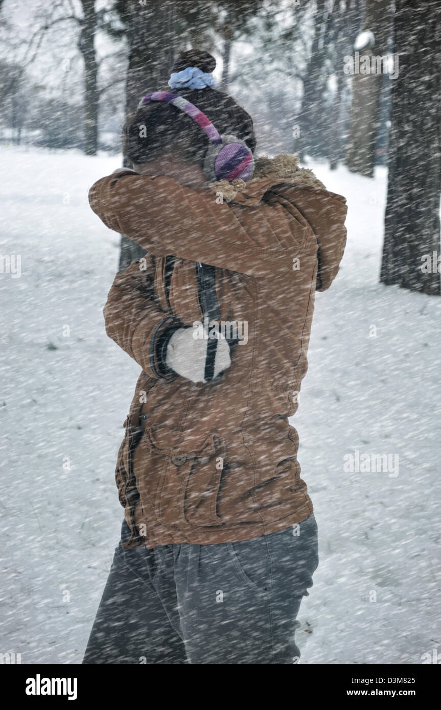 Young woman caught up in a snow storm Stock Photo