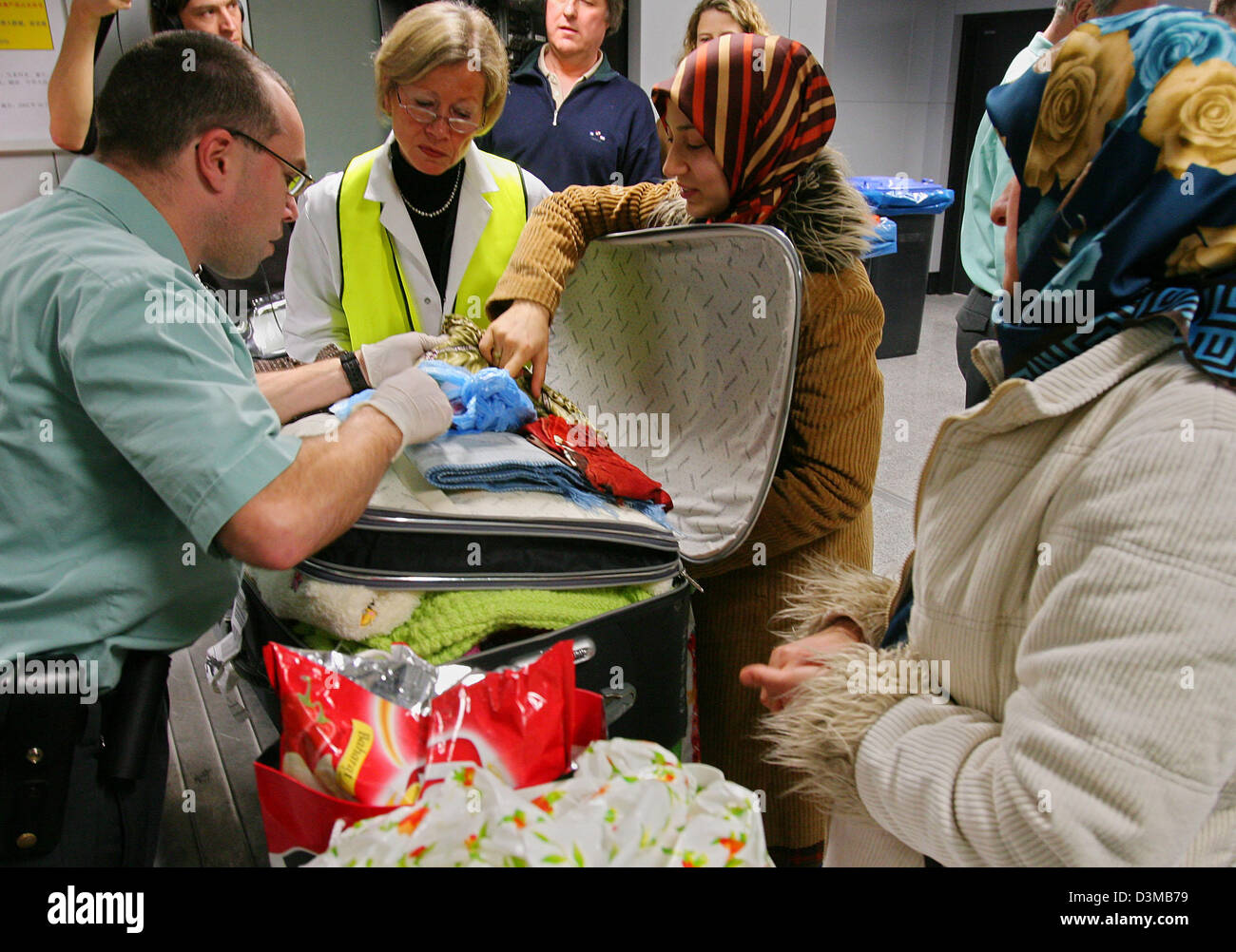 (dpa) - Wearing rubber gloves, customs staff search the luggage of a woman coming in from Ankara at the airport in Frankfurt Main, Germany, Monday 16 January 2006. With these measures, authority aim to prevent the influx of infected fowl products. After the incidence of various avian influenza cases in Turkey security checks in Germany  are being continued. Photo: Boris Roessler Stock Photo
