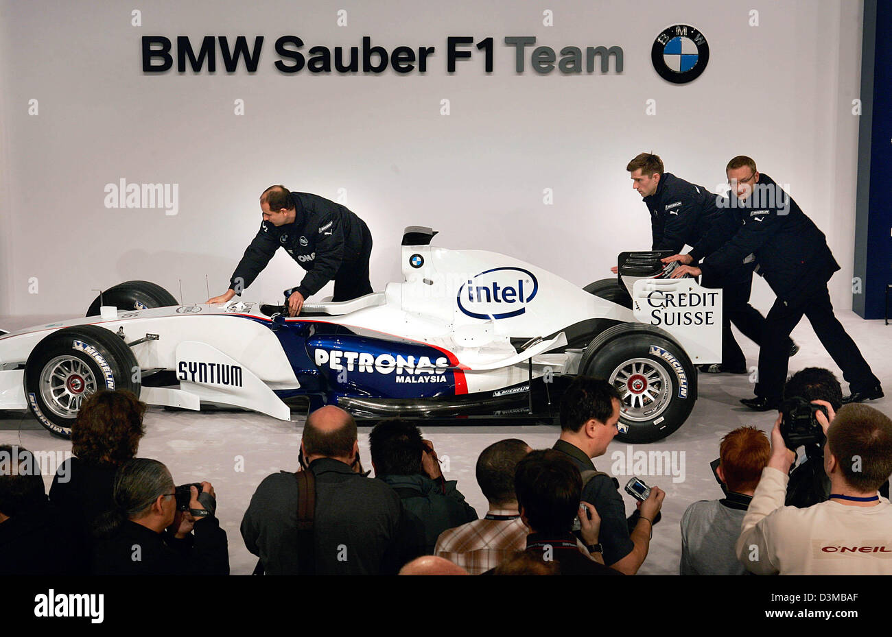 dpa) - Staff members of the BMW Sauber F1 Team roll the 'F1.06' race car off