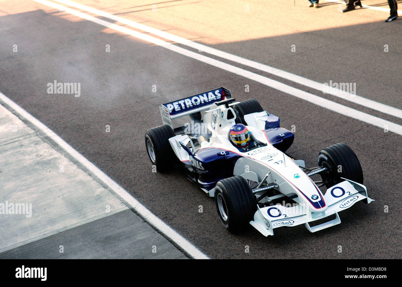 (dpa) - Canadian Formula One pilot Jacques Villeneuve returns to the pits with steaming new BMW Sauber F1 Team race car 'F1.06' after its first rollout on the race track of Valencia, Spain, Tuesday 17 January 2006. The old engine overheated in the new chassis. Photo: Gero Breloer Stock Photo