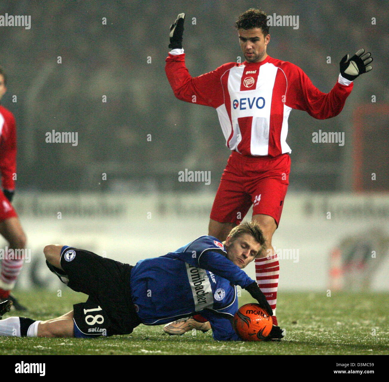 Arminia Bielefeld's Artur Wichniarek stops the ball like a goalkeeper in a duel with Kickers Offenbach's Matej Milijatovic (R) during the German Cup quarter-finals soccer match at the Schueco Arena stadium in Bielefeld, Germany, Wednesday 25 January 2006. Around12,000 spectators watched Bielefeld advance to the semi-finals after a penalty shoot-out. Photo: Franz-Peter Tschauner Stock Photo