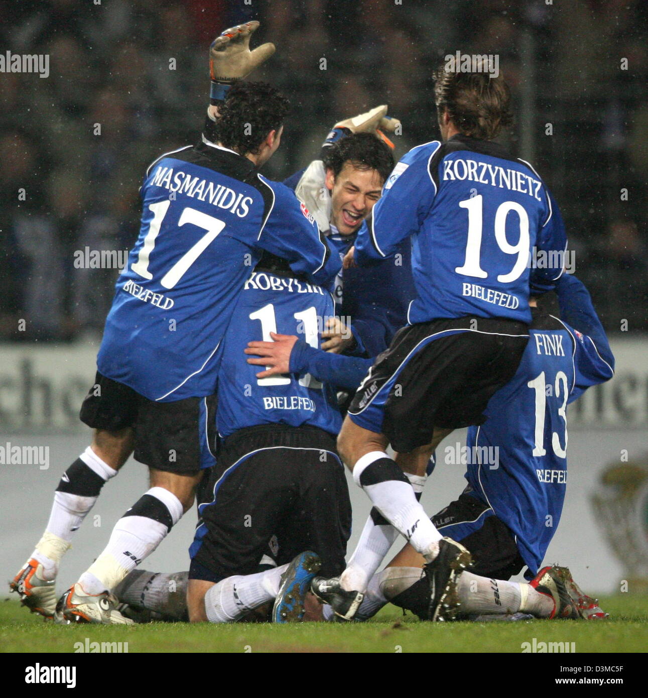Arminia Bielefeld's Ioannis Masmanidis, David Kobylik, Markus Schuler, Bernd Korzynietz and Michael Fink (L-R) celebrate their team's triumph over Kickers Offenbach after the German Cup quarter-finals soccer match at the Schueco Arena stadium in Bielefeld, Germany, Wednesday 25 January 2006. Around12,000 spectators watched Bielefeld advance to the semi-finals after a penalty shoot- Stock Photo