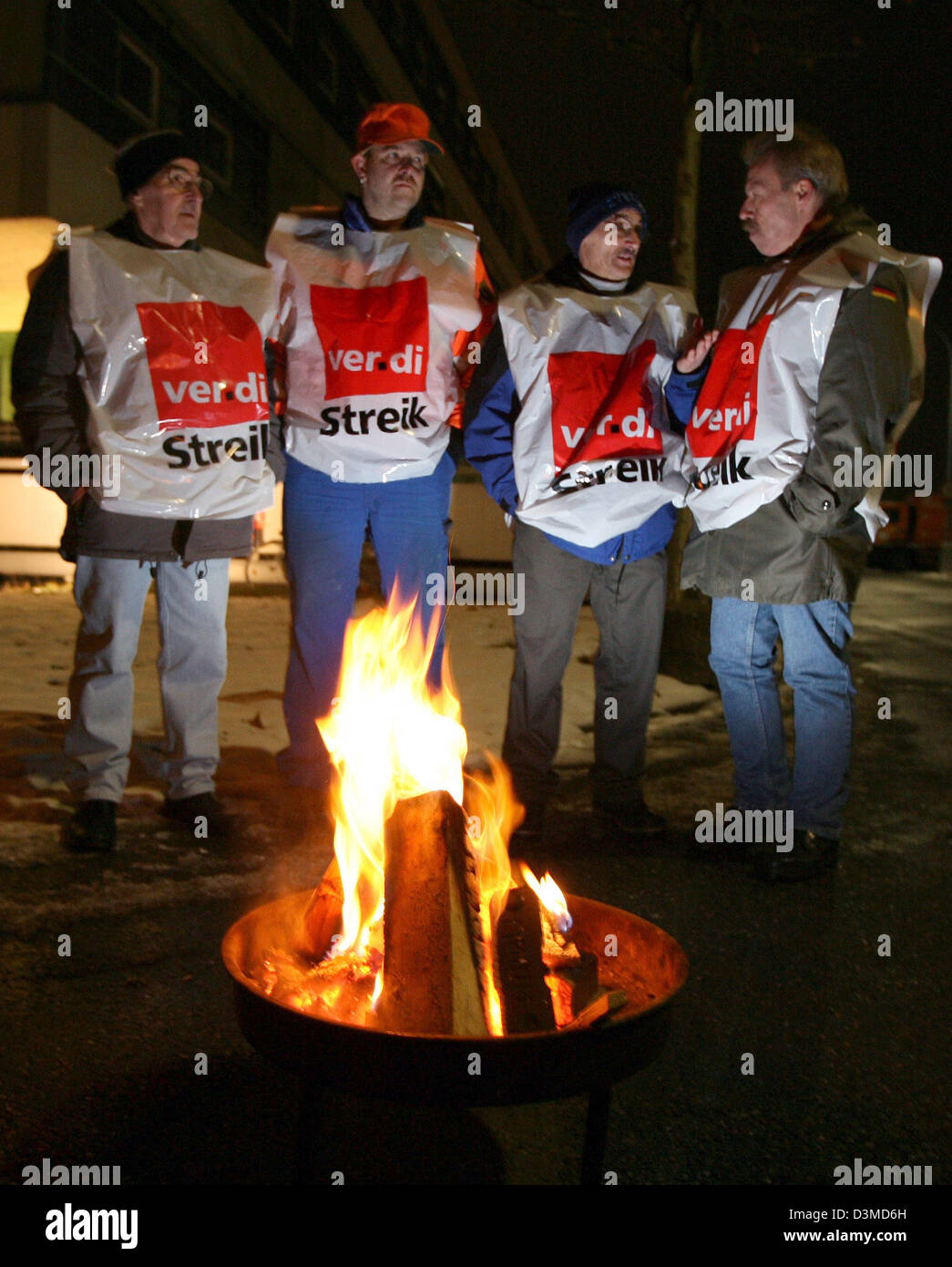 Strike pickets of the local waste disposal services stand around a fire in Freiburg, Germany, Monday, 06 February 2006. The largest strike in 14 years has began today in the public services sector in the state of Baden-Wuerttemberg. Refuse collectors, hospital staff as well as staff of wastewater treatment plants and many others have put down their work in all larger cities in Bade Stock Photo