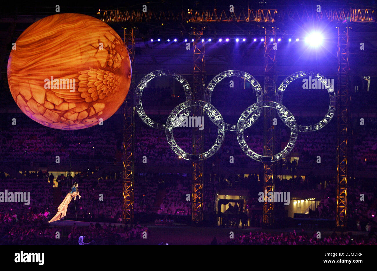 Float Singer The Olympic Rings illuminate the night while a singer floats by in a ...