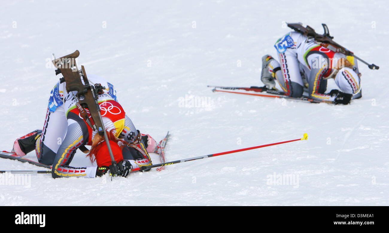 German biathlete Kati Wilhelm (L) and Martina Glagow exhaustedly crouch on the floor pictured at the 7,5 Women's Sprint biathlon competition in San Sicario, Italy, Thursday 16 February 2006.  Wilhelm finished 7th place and Glagow 17th place. Photo: Arne Dedert Stock Photo