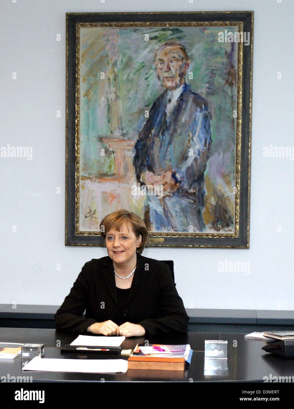 German Chancellor Angela Merkel of the Christian Democrats (CDU) sits hat her desk in front of a painting depicting former German Chancellor Konrad Adenauer (1876-1967) at the chancellery in Berlin, Tuesday, 21 February 2006. The painting by Austrian-born artist Oskar Kokoschka (1886-1980), which was part of a valume of stocks of art work belonging to the Bundestag parliament, was  Stock Photo