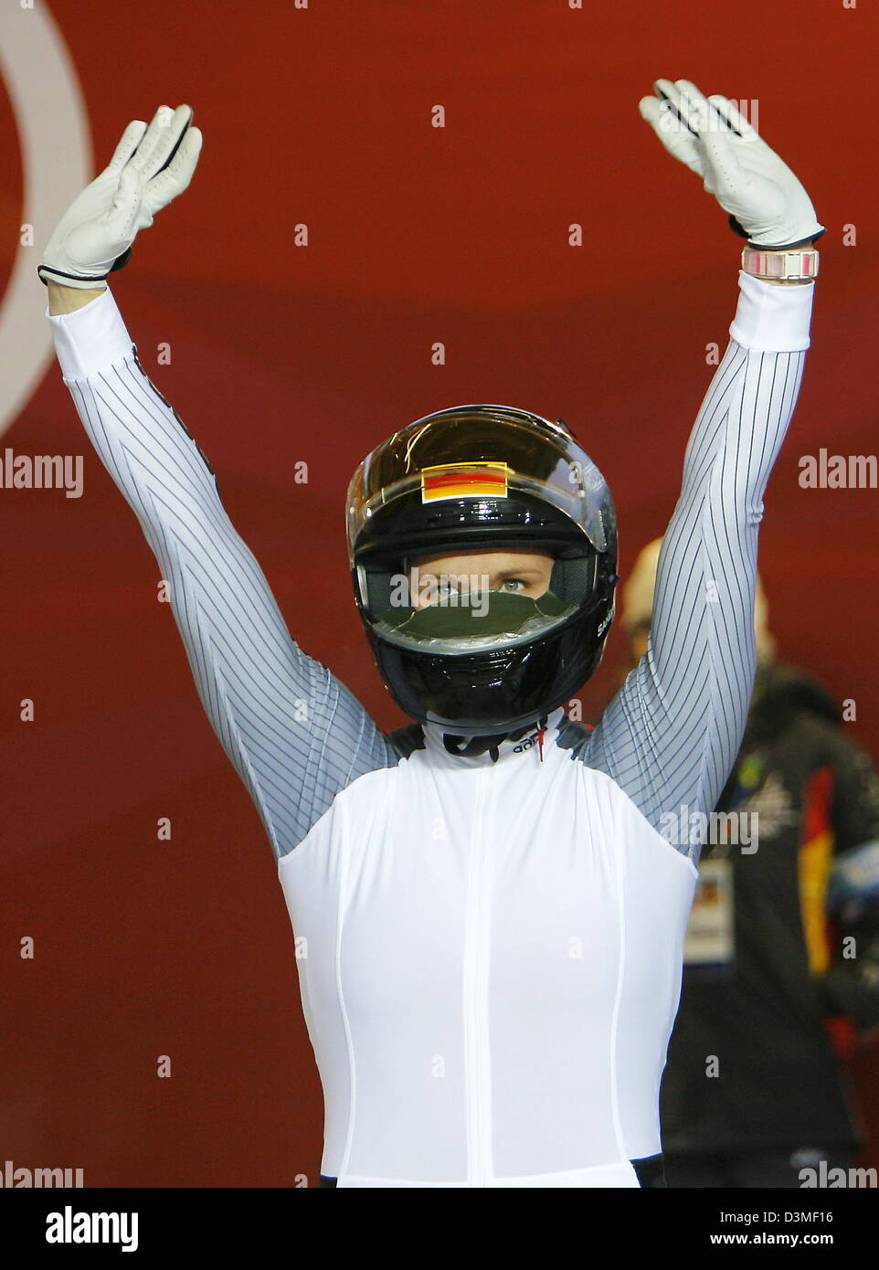 German bobsleigher Sandra Kiriasis raises her arms and waves still wearing her helmet after taking the lead in the third heat of the  Women's Double Bobsleighing event on the Olympic Toboggan run at the Turin Winter Olympics in Cesana Pariol, Italy, Tuesday, 21 February 2006. Kiriasis and her teammate Anja Schneiderheinze eventually won gold. Photo: Arne Dedert Stock Photo