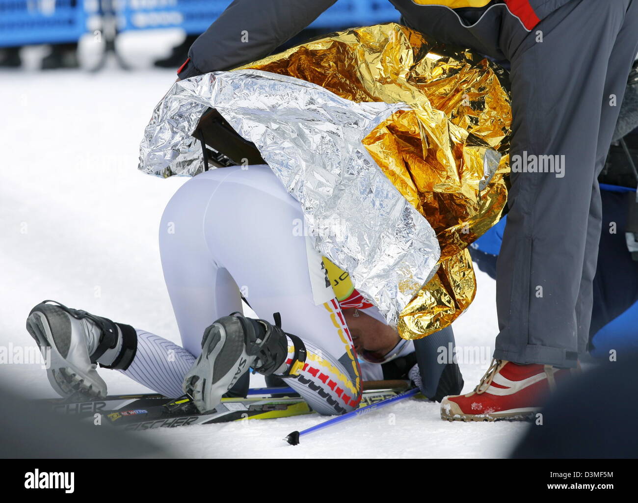 An aid covers exhausted German biathlete Katrin Apel with a thermo blanket in the Women's 4 x 6 km Biathlon Relay at the Olympic Winter Games in San Sicario, Italy, Thursday, 23 February 2006. The German women's relay team won silver. Photo: Arne Dedert Stock Photo