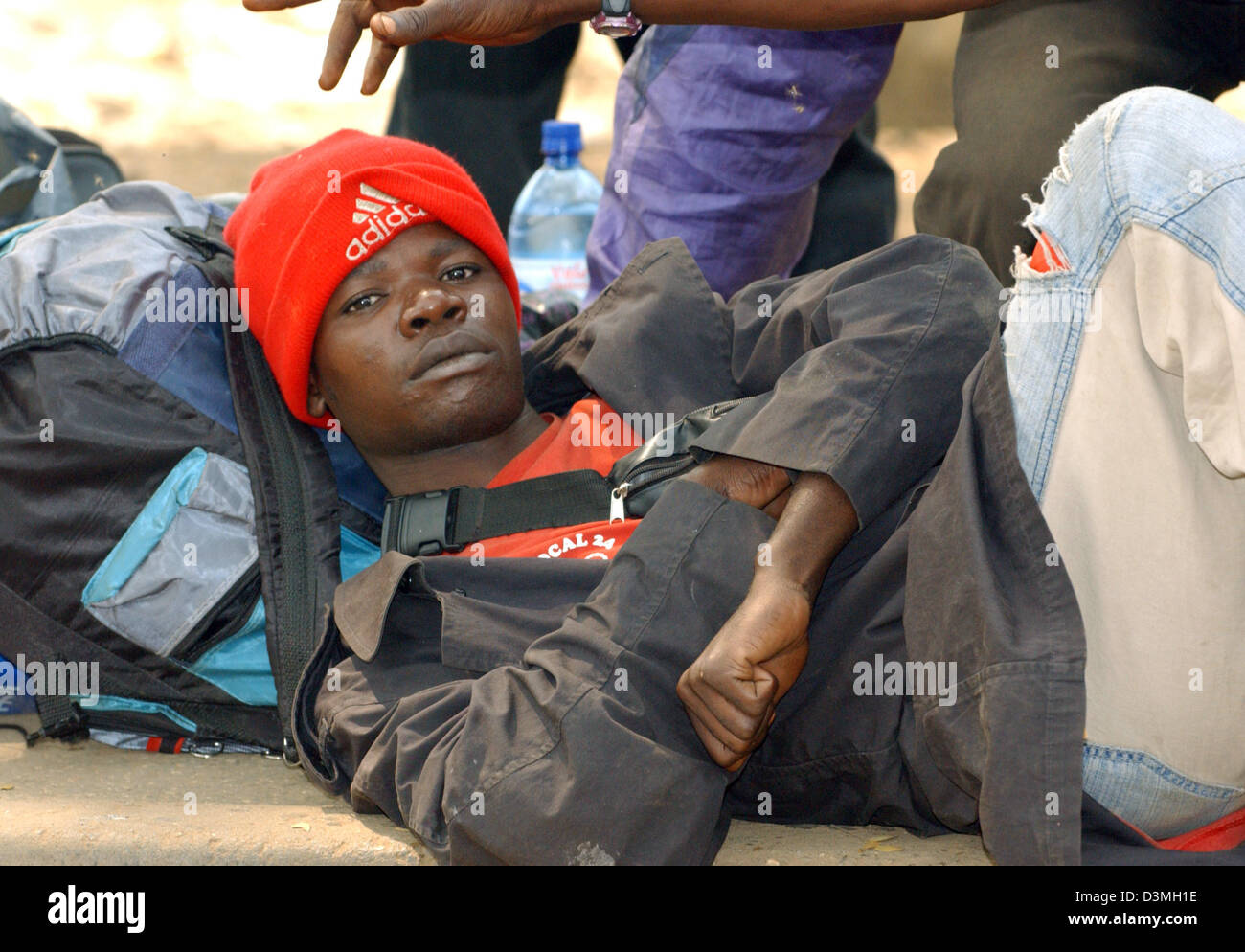 (dpa file) A day labourer lies on the roadside waiting for a job opportunity in the capital of Luanda, Angola, 20 July 2005. Photo: Wolfgang Langenstrassen Stock Photo