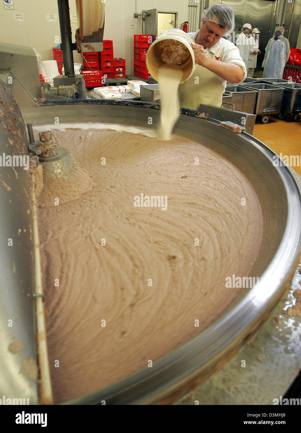 An employee of  'Ruegenwalder Muehle' pours some flavouring into a huge boiler full of sausage mass at the company's factory site in Bad Zwischenahn, Germany, Thursday, 16 March 2006. The company makes amongst others the famous 'Teewurst' (smoked pork pate), which is a registered trademark since 1957. Photo: Ingo Wagner Stock Photo