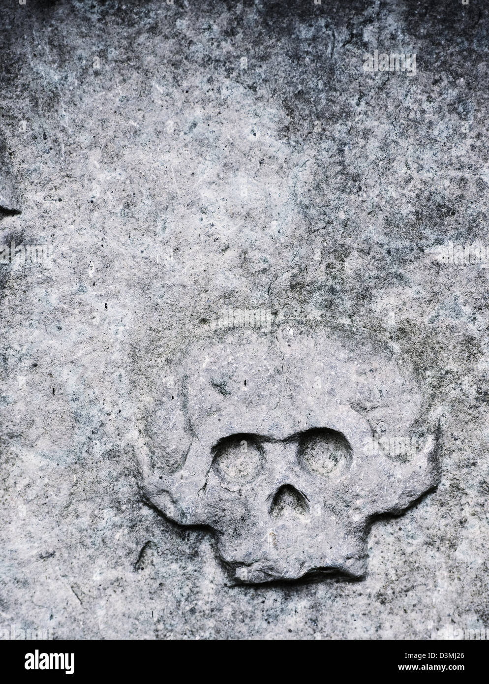 Tombstone with ominous engraving of an old skull Stock Photo