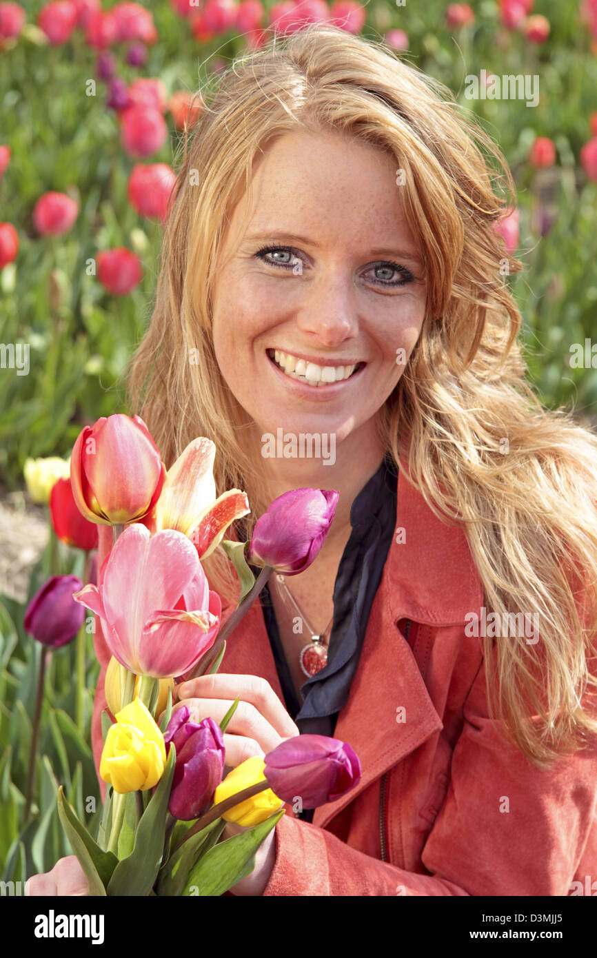 Dutch woman between the flower fields in the Netherlands Stock Photo