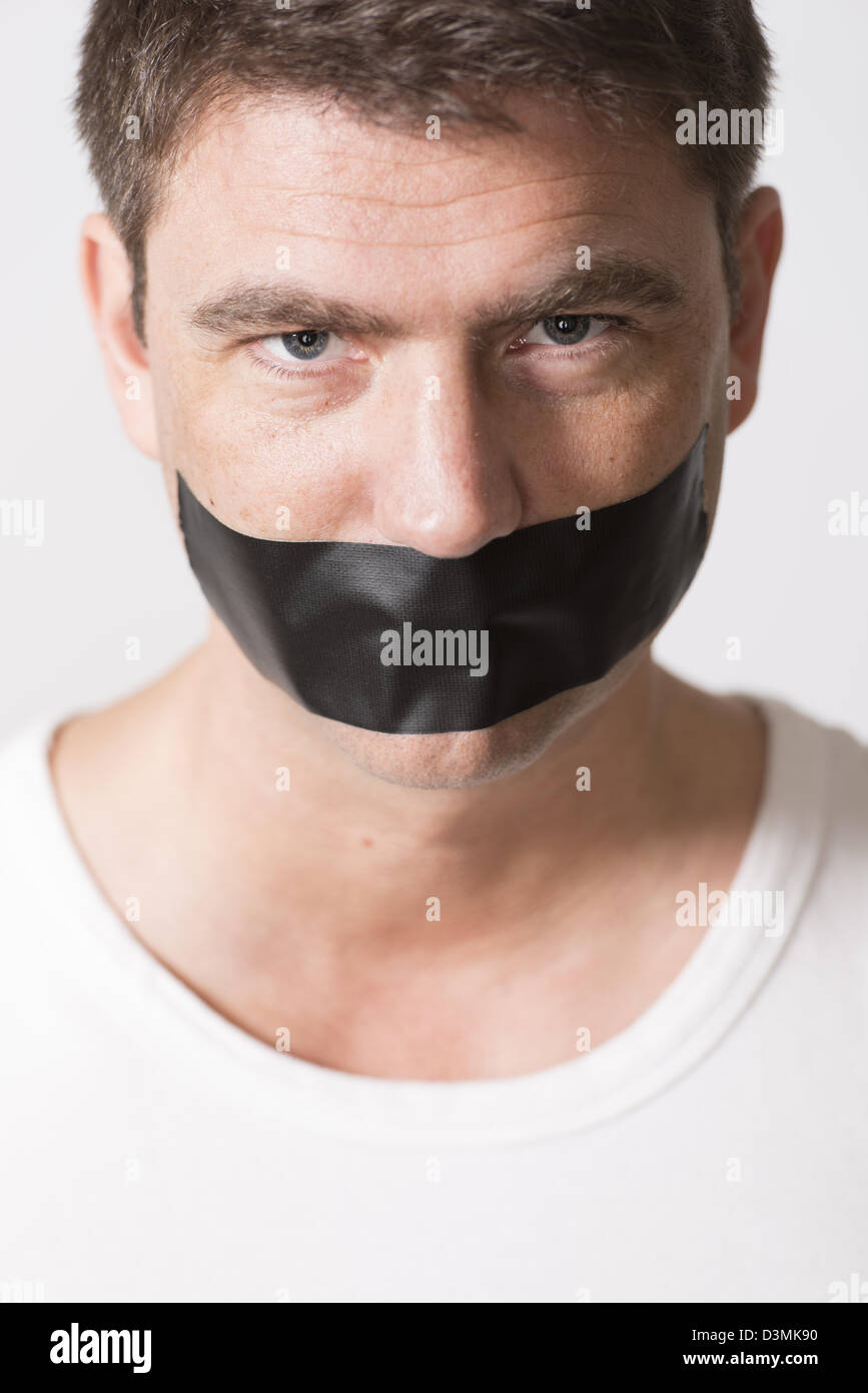 Masculine adult male silenced with black tape over mouth Stock Photo