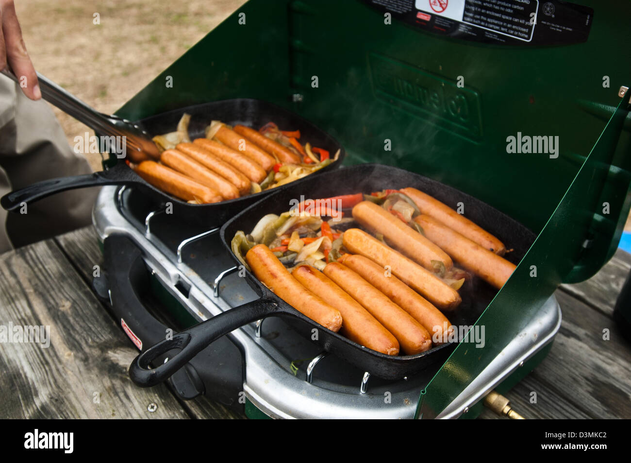 Cooking bratwurst on a gas camp stove on The White River, Cotter Arkansas Stock Photo