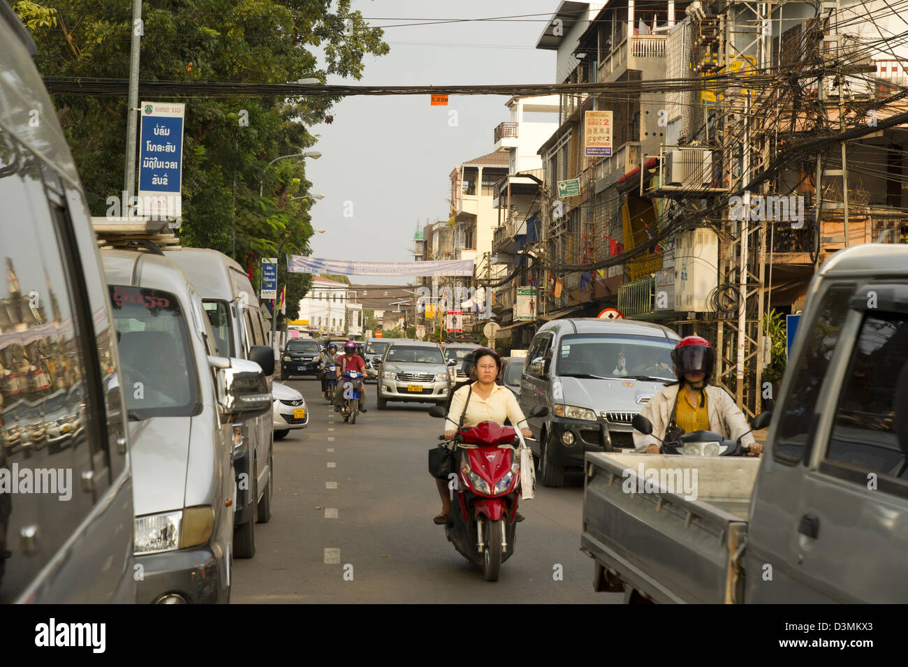 Cars and motorbikes jockey for position in the morning traffic in Vientiane, Laos. Stock Photo