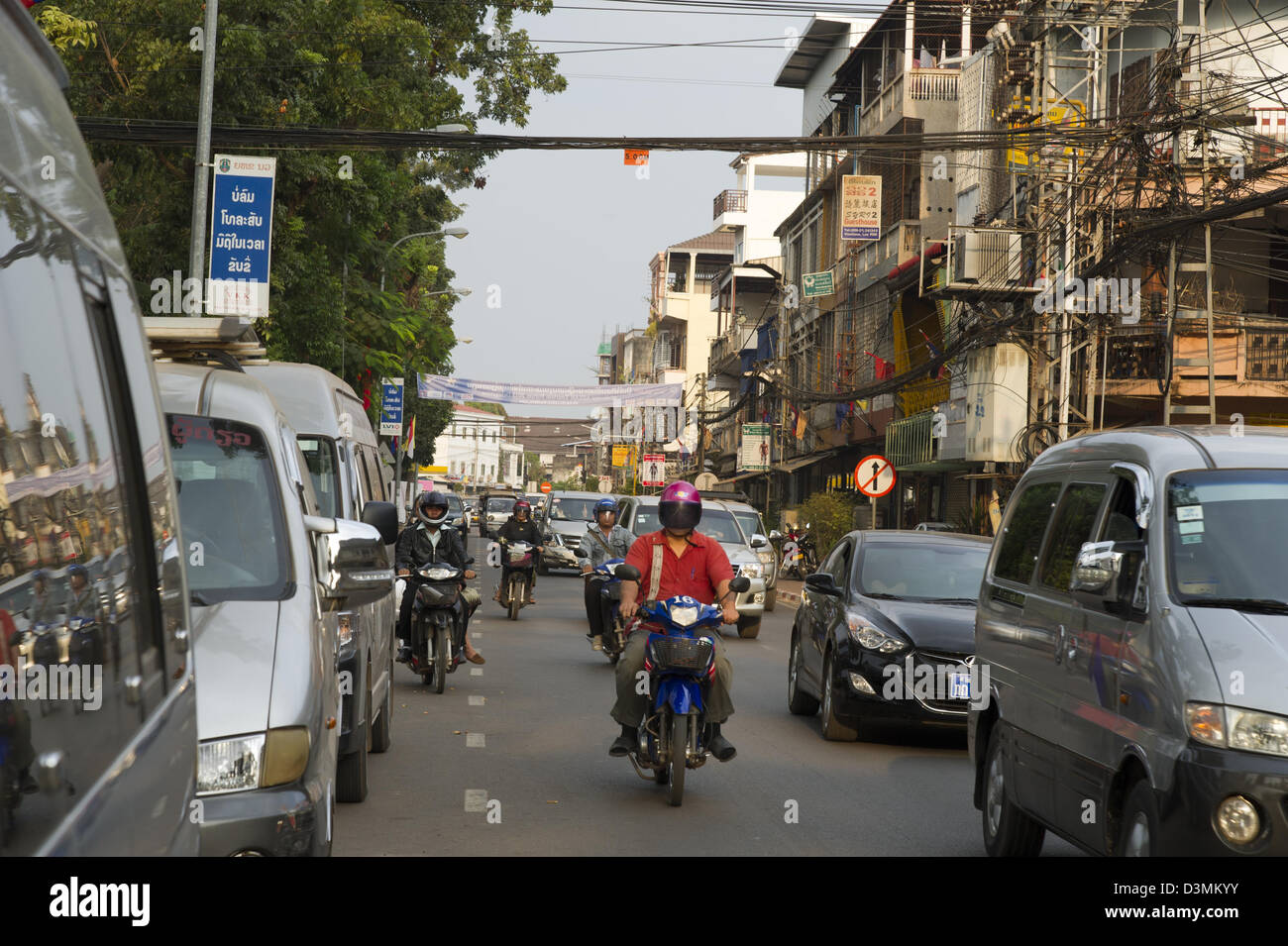 Cars and motorbikes jockey for position in the morning traffic in Vientiane, Laos. Stock Photo