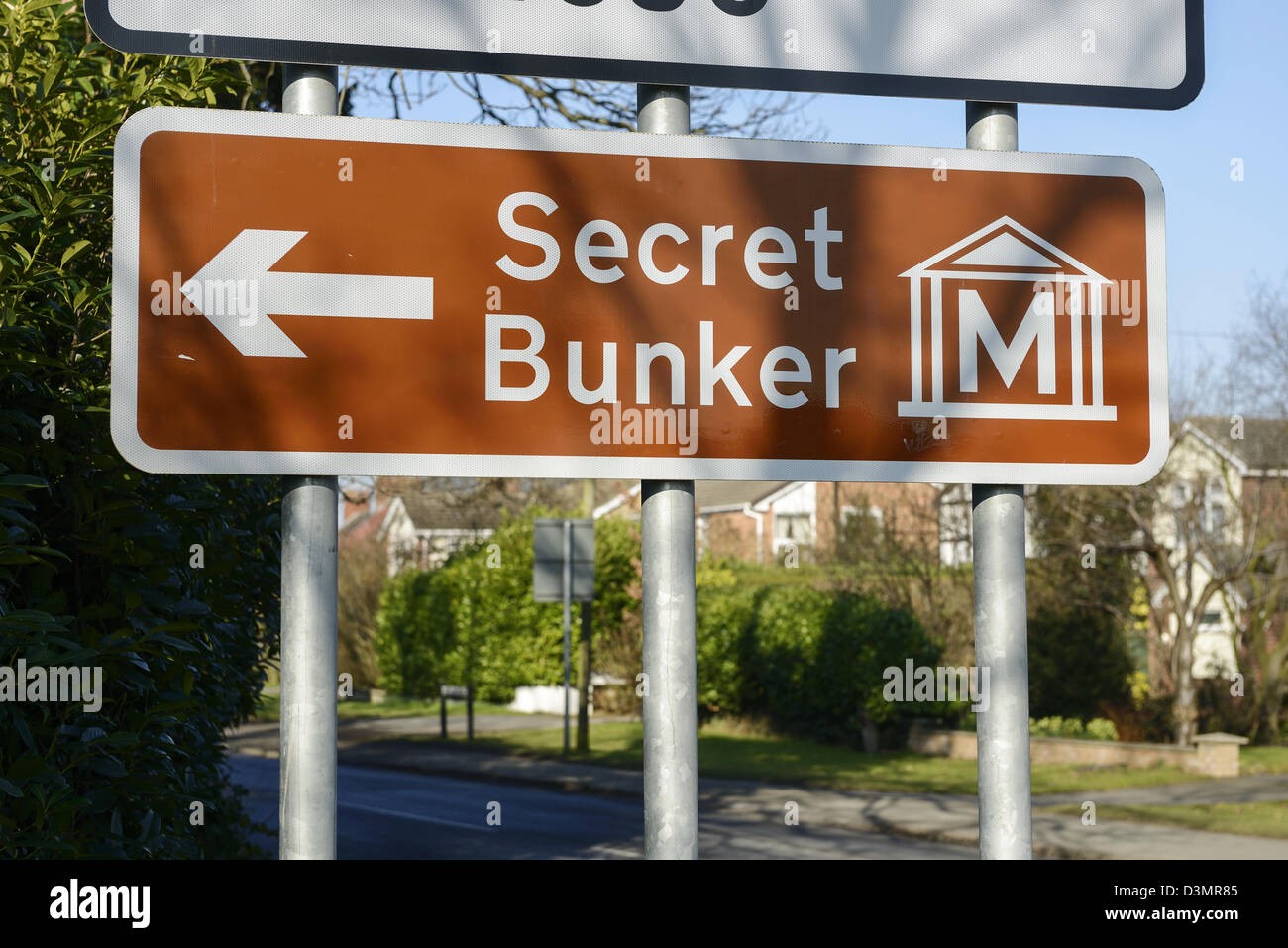 Brown road sign pointing to a Secret Bunker Stock Photo