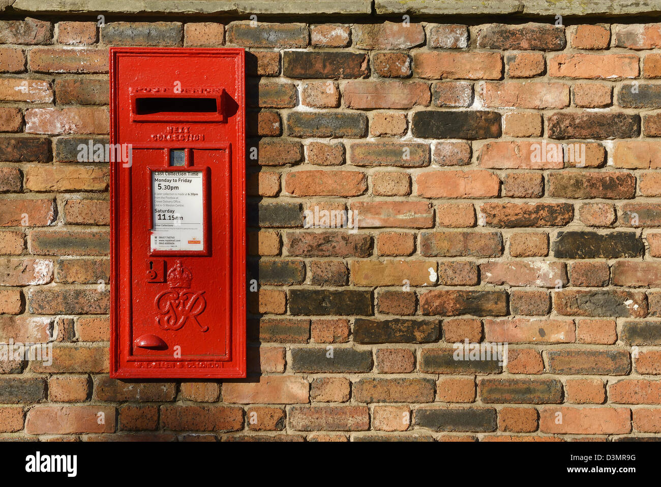 Royal Mail red post box in a brick wall Stock Photo