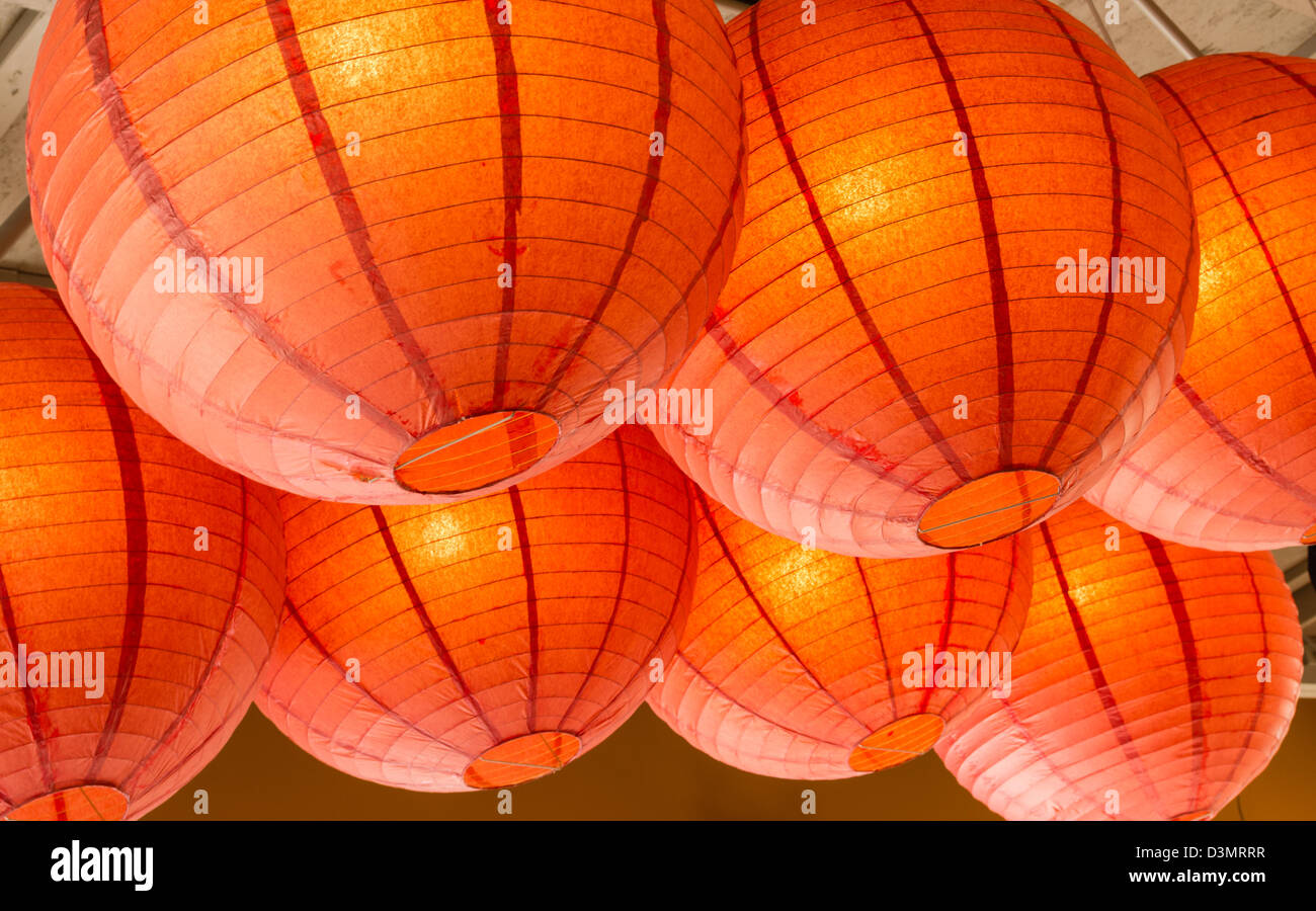 A Group Of Orange Paper Lanterns Hanging From The Ceiling Stock