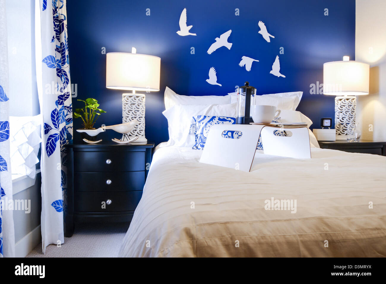 Modern master bedroom with blue wall and white linens Stock Photo - Alamy