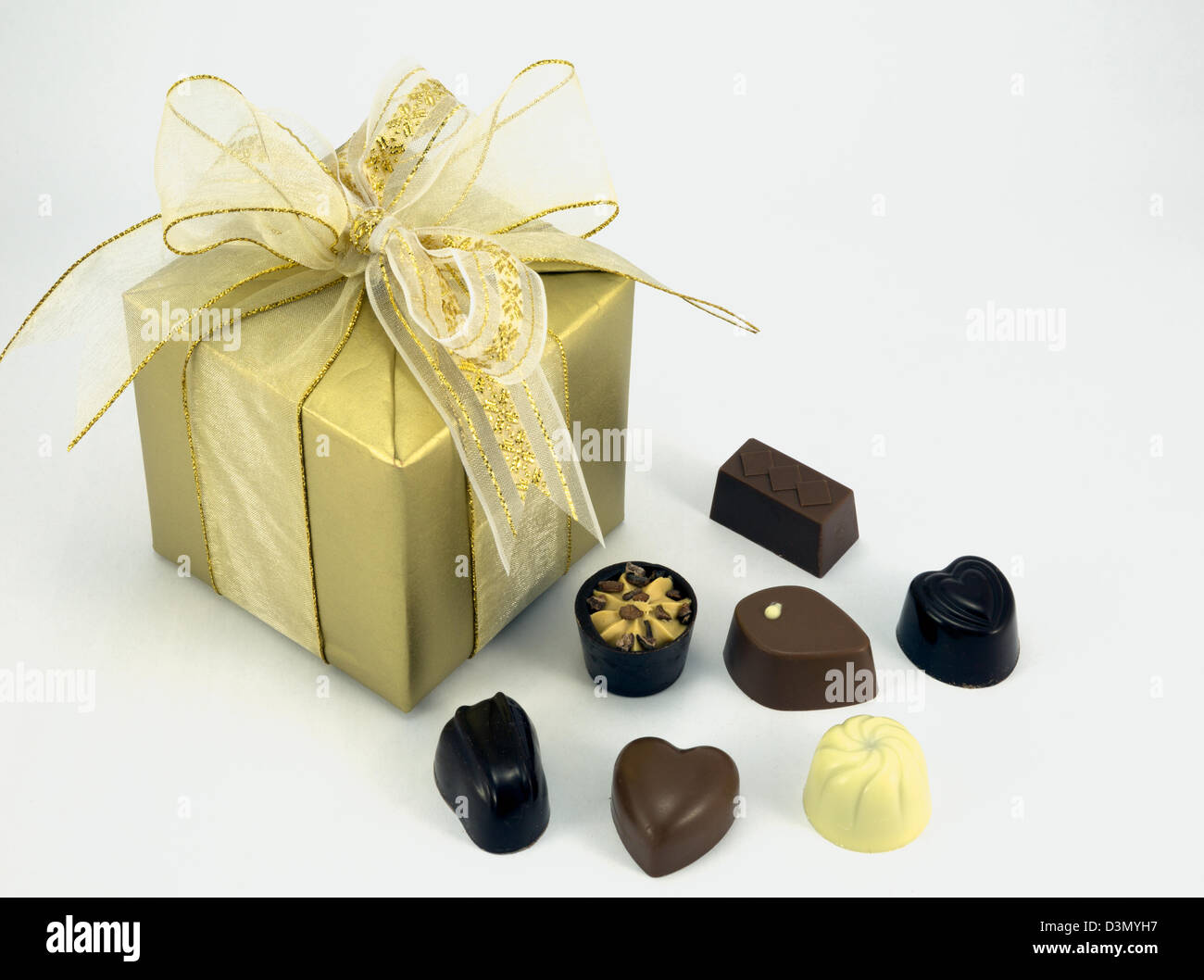 Gold wrapped present with assorted chocolates Stock Photo - Alamy