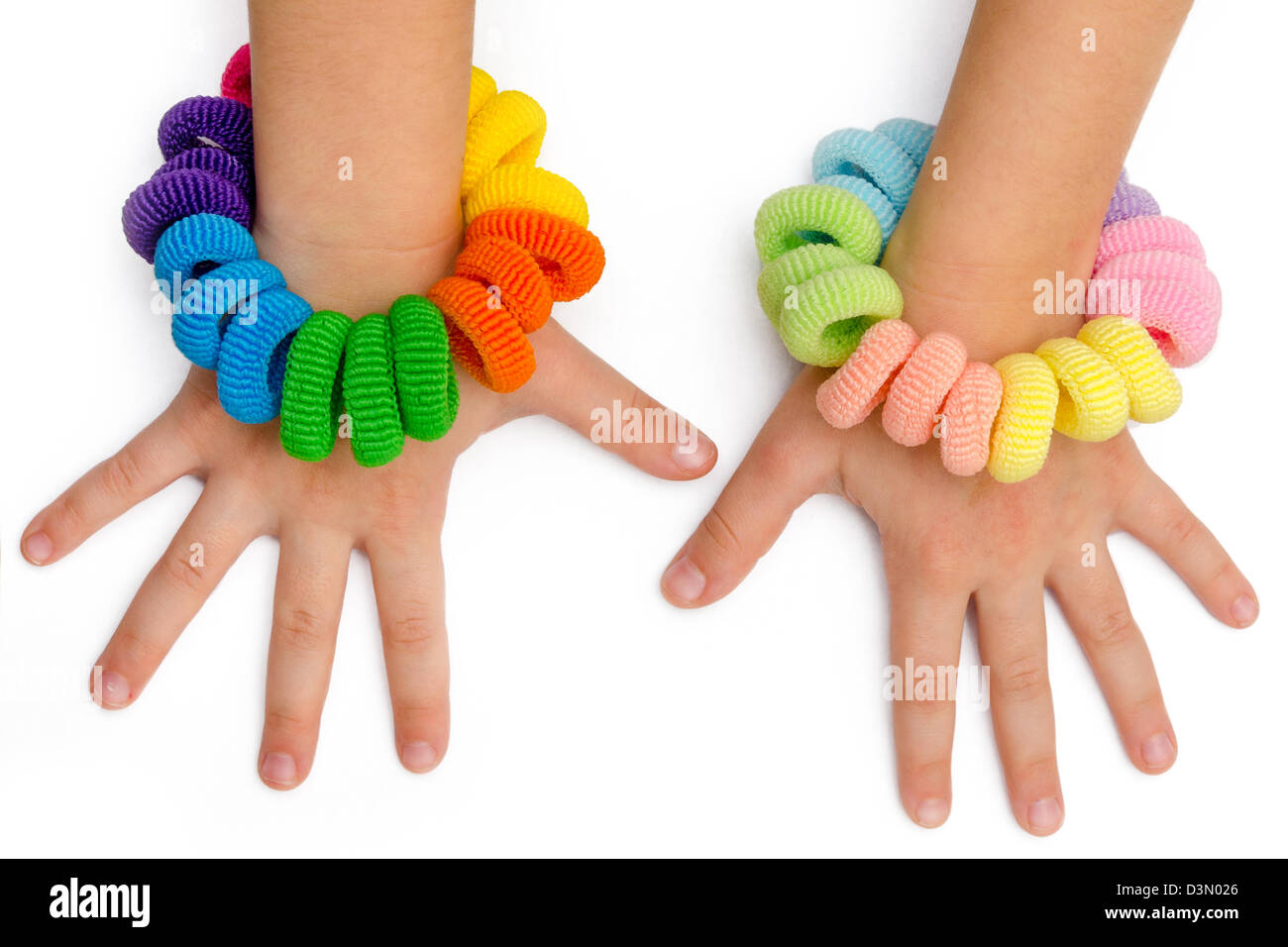 hands of a little girl with hair bands of many colors Stock Photo