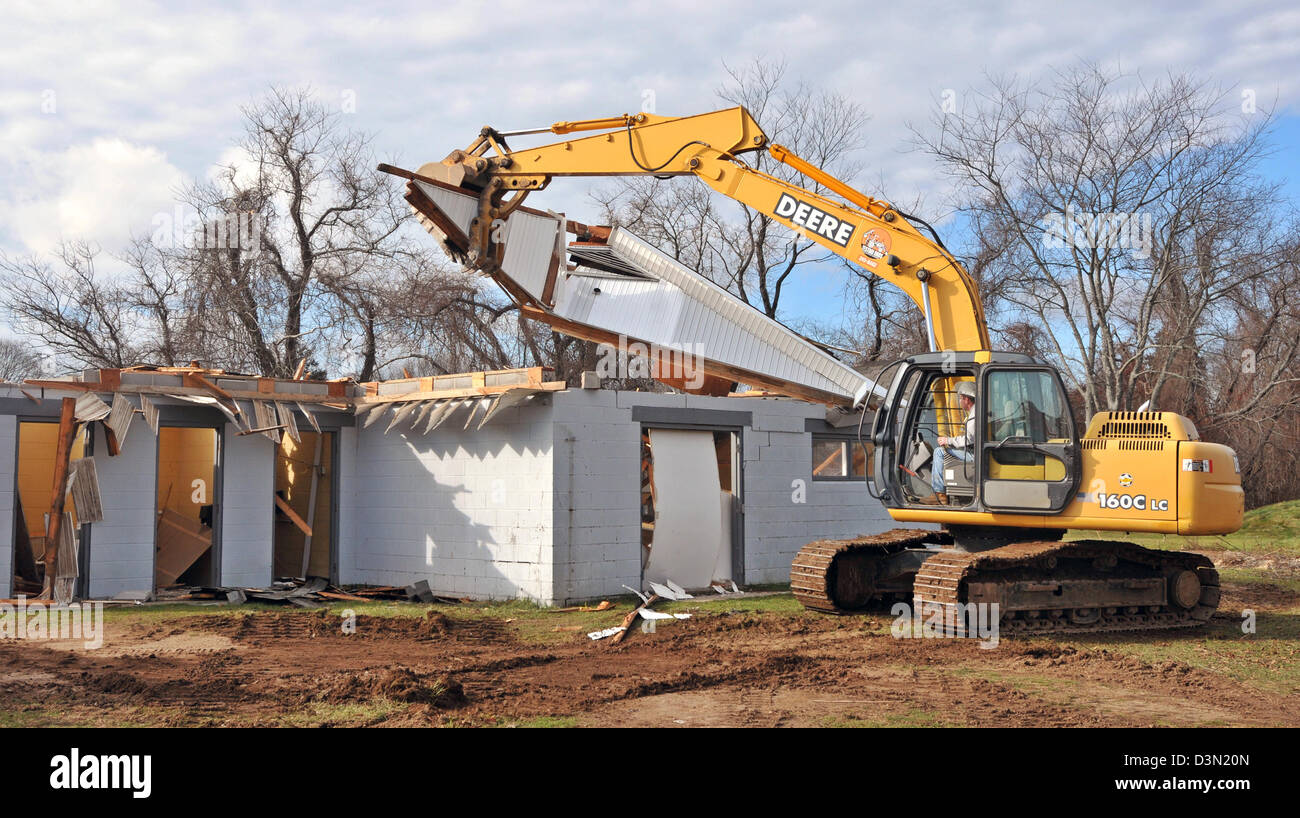 A wrecker tears down the bathrooms at a football stadium in Madison CT USA as the town prepares to build a new one. Stock Photo