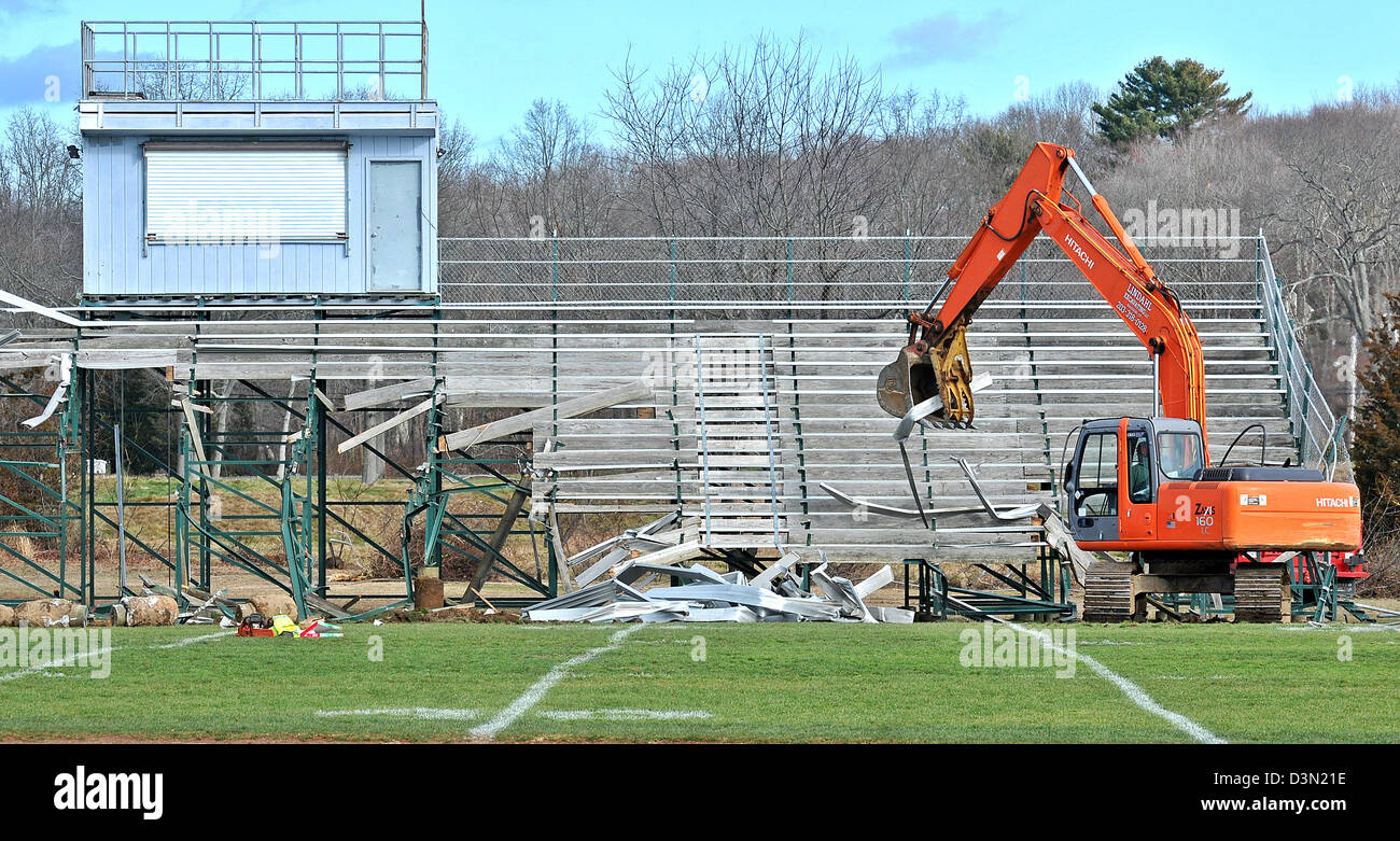 A wrecker tears down the bleachers at a football stadium in Madison CT USA as the town prepares to build a new one. Stock Photo