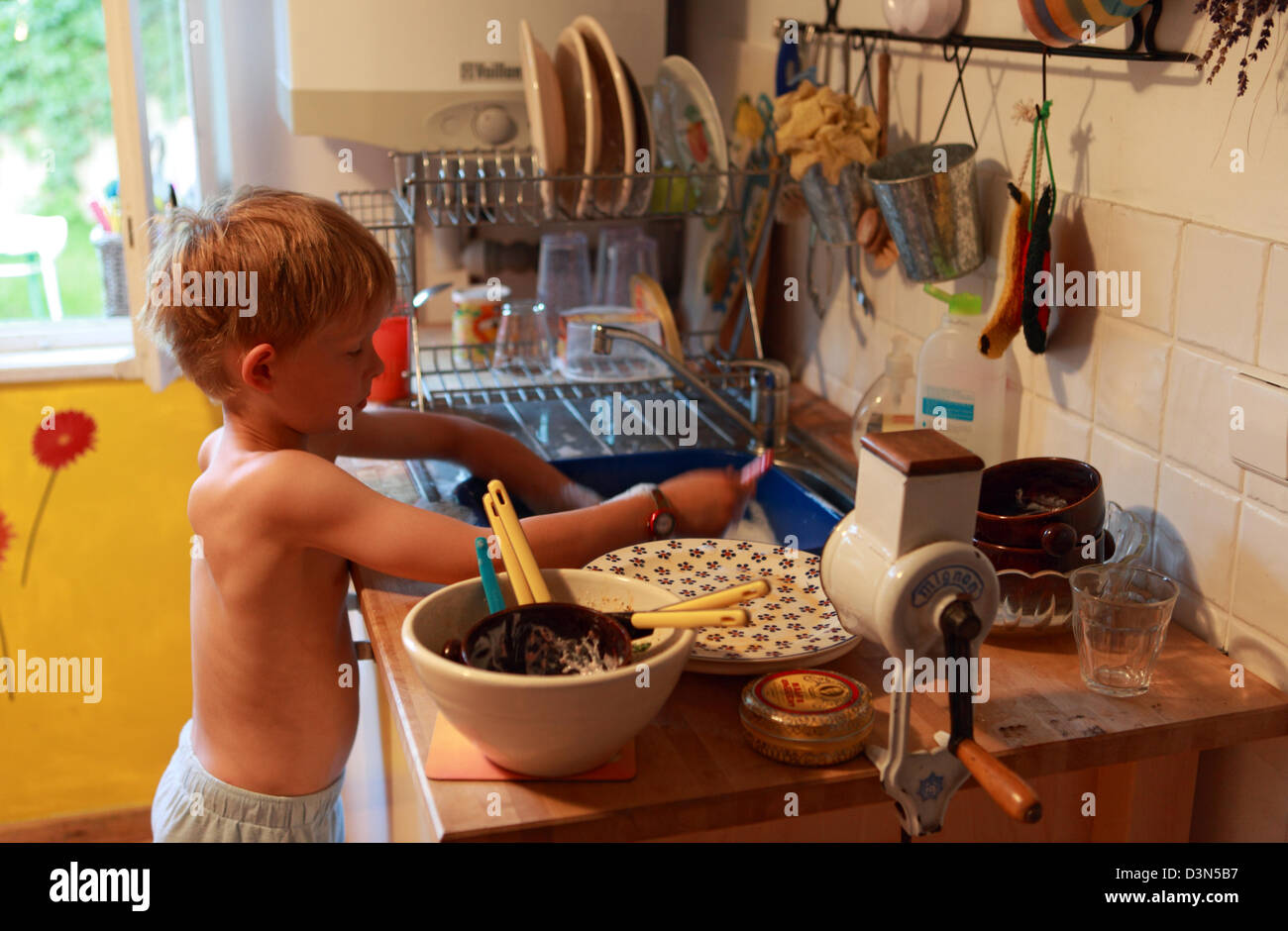 Berlin, Germany, boy washes dishes Stock Photo
