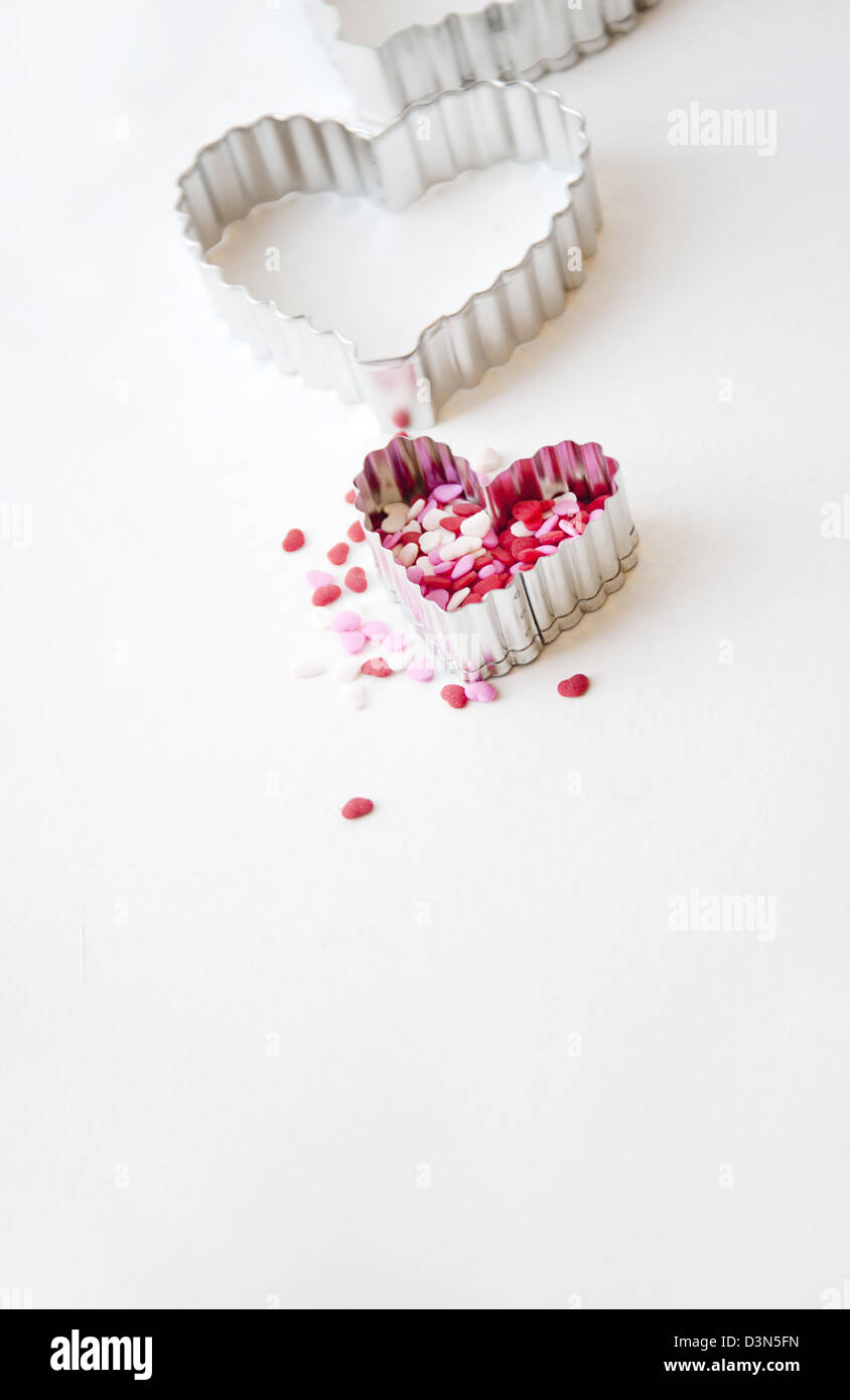 Heart shaped cookie cutters and cake sprinkles or decorations for baking Stock Photo