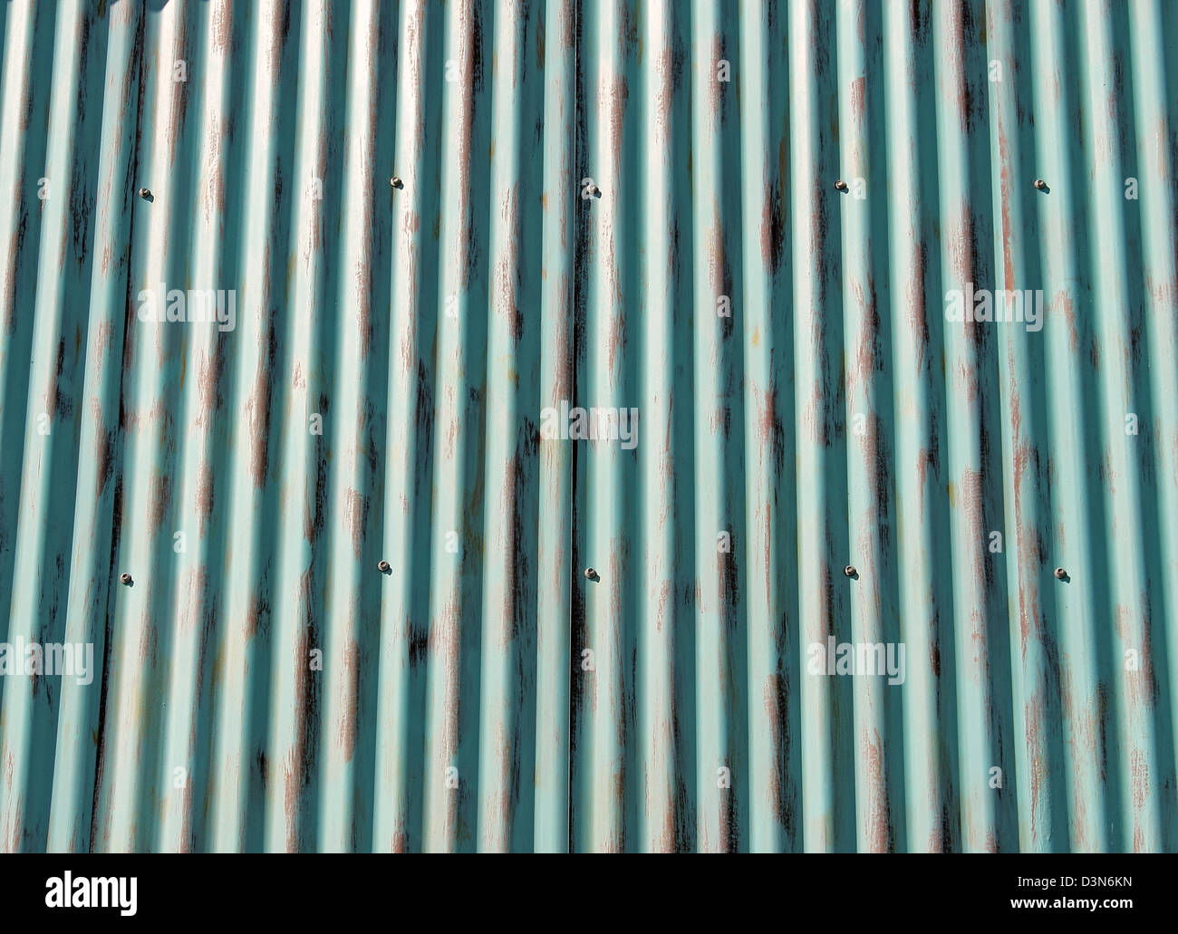 Protective sheets of corrugated aluminum sheeting screwed together as a background. Stock Photo