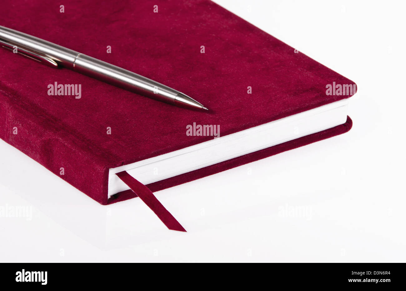 Red journal and a pen over white background Stock Photo